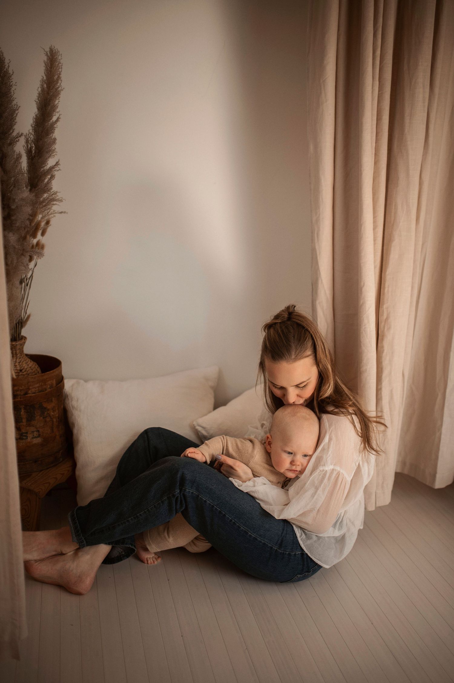 Förälder och bebis delar en glad stund under en familjefotografering i Hässleholm.