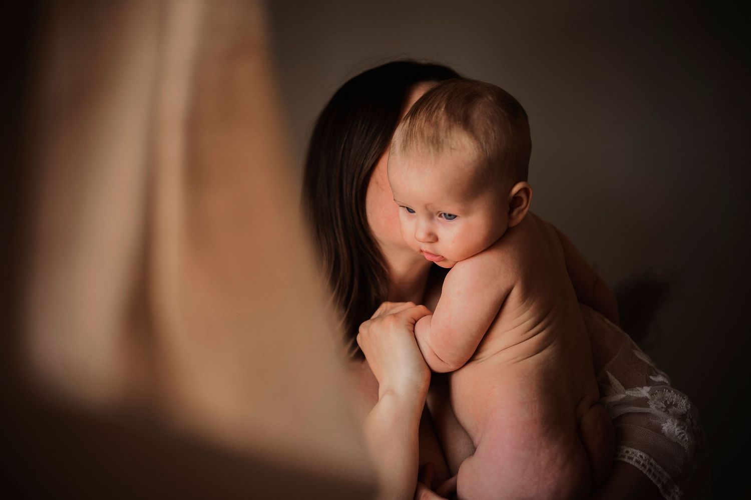 moderskapsfotografering i Hässleholm med mamma och bebis i hemmiljö i en intim stund.