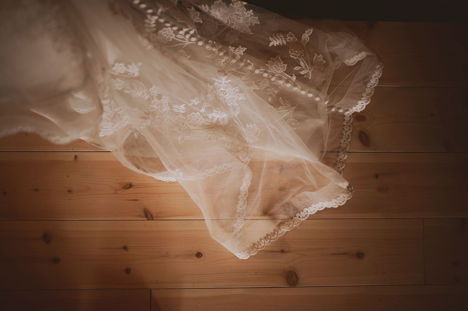 Bröllopsfotografering i Skåne med detaljer av spetsbrudklänning i mjukt naturligt ljus inomhus.