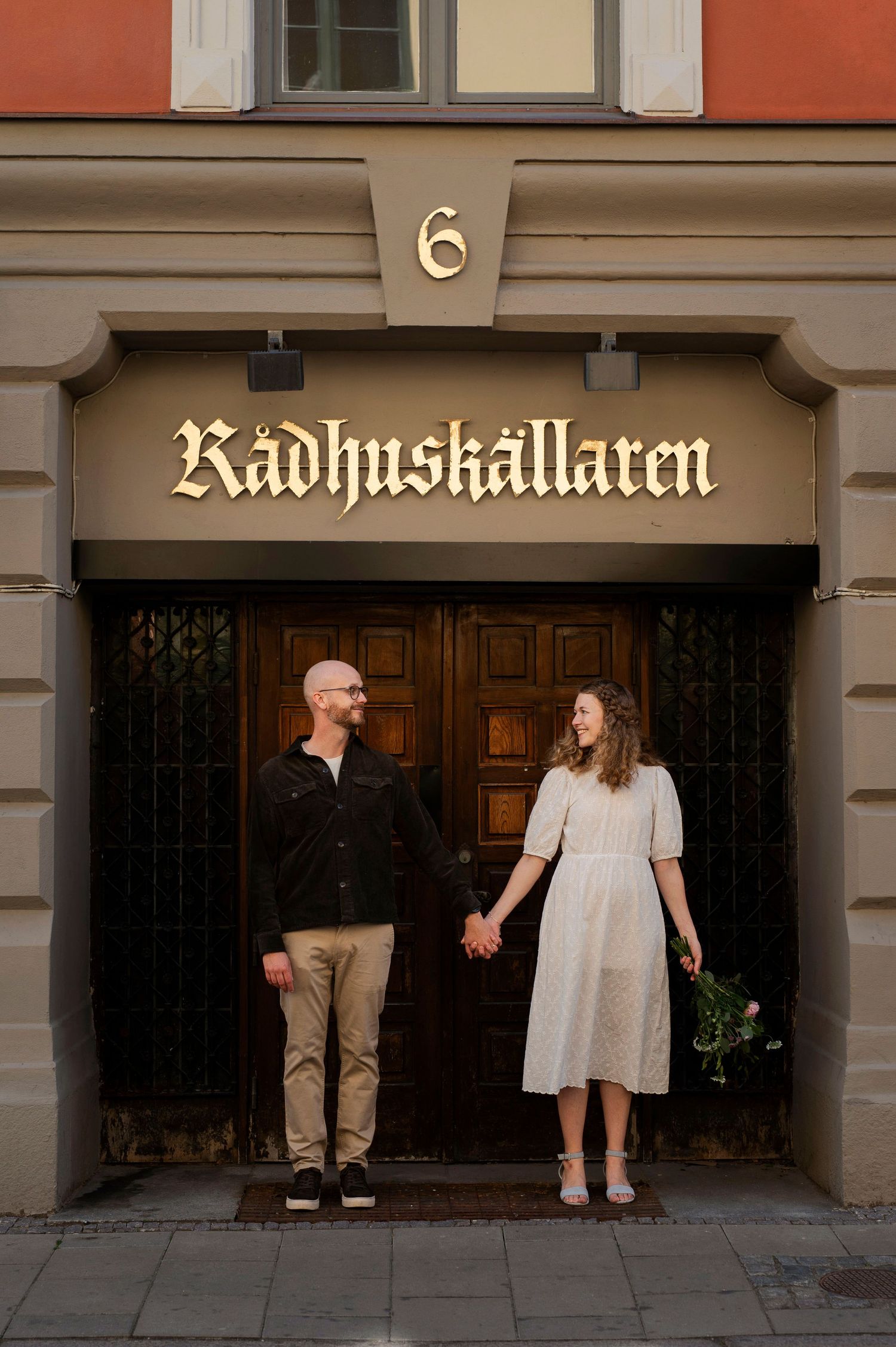 Bröllopsfotografering i Malmö med brudpar som håller händer vid Rådhuskällaren vid Rådhuset.