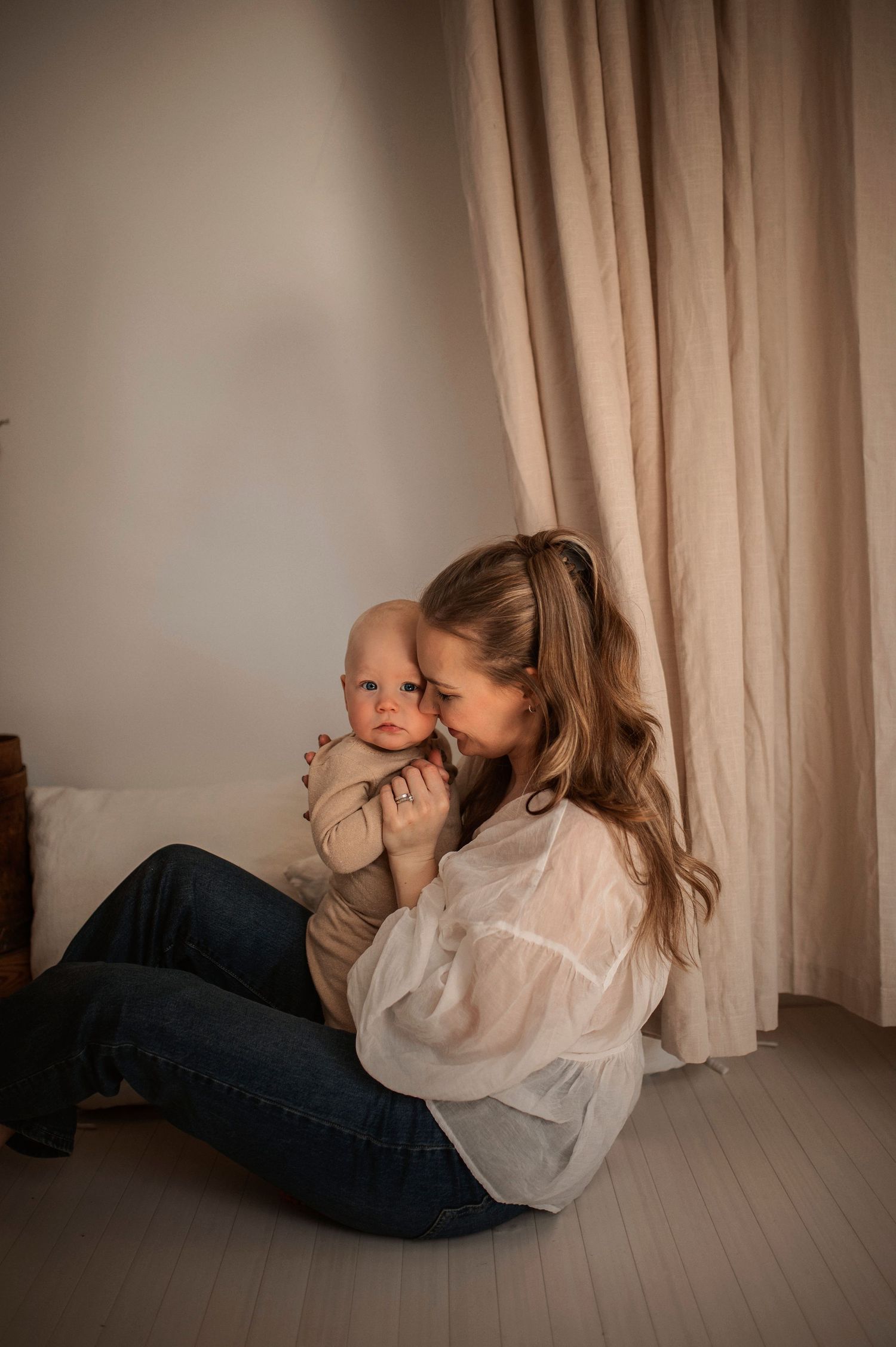 Förälder och bebis delar en glad stund under en familjefotografering i Hässleholm.