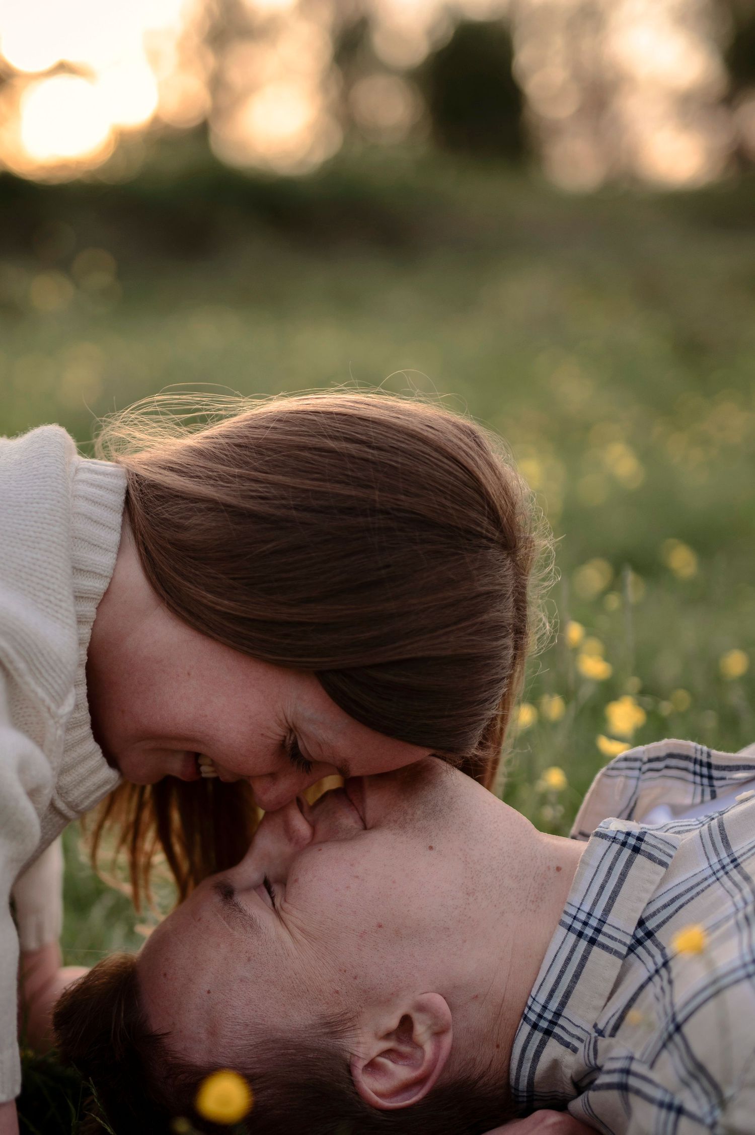 Par fotograferat i en blommande äng under en romantisk parfotografering i Skåne i kvällsljus.