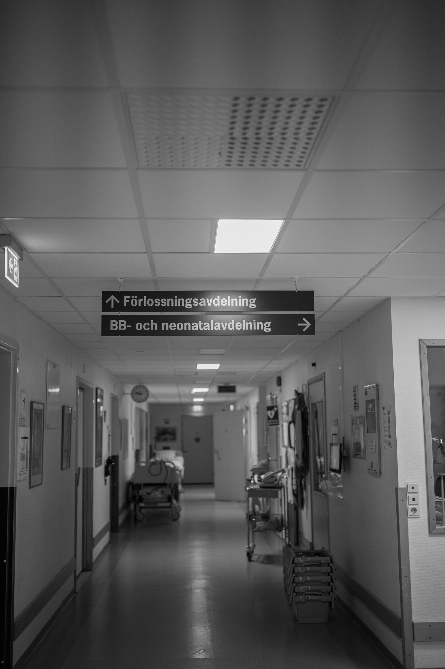 Förlossningsfotografering i Skåne med skyltar till förlossning och neonatalavdelning i sjukhuskorridor.