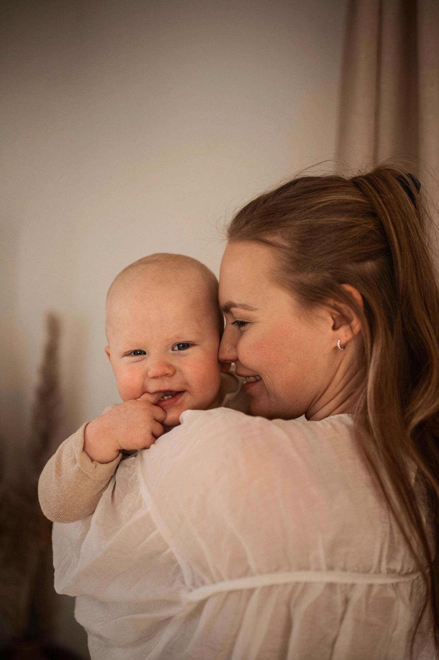 Förälder och bebis delar en glad stund under en familjefotografering i Hässleholm.