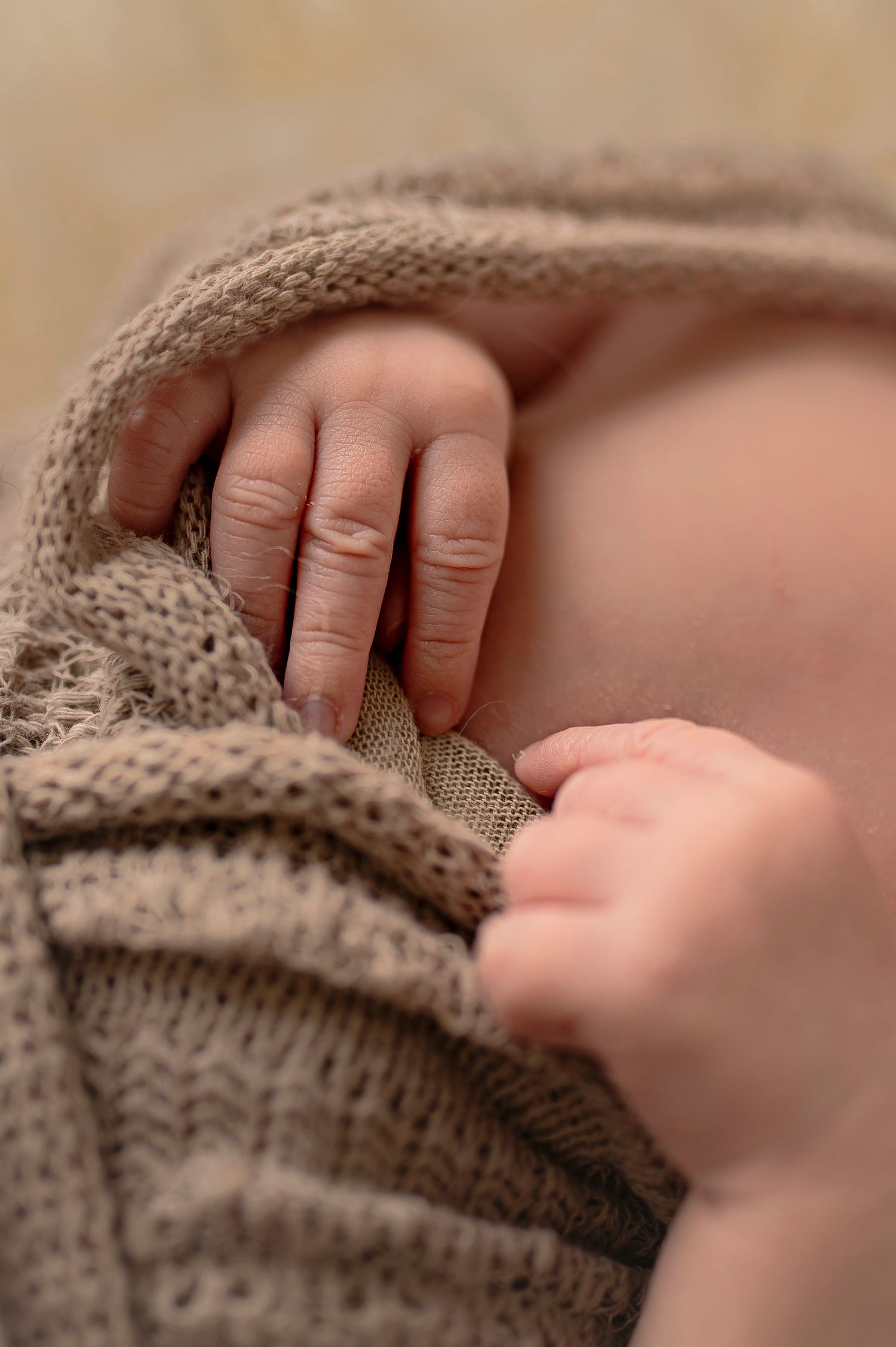 Närbild på nyfödd bebis fingrar under en nyföddfotografering i Hässleholm i mjuka neutrala toner.