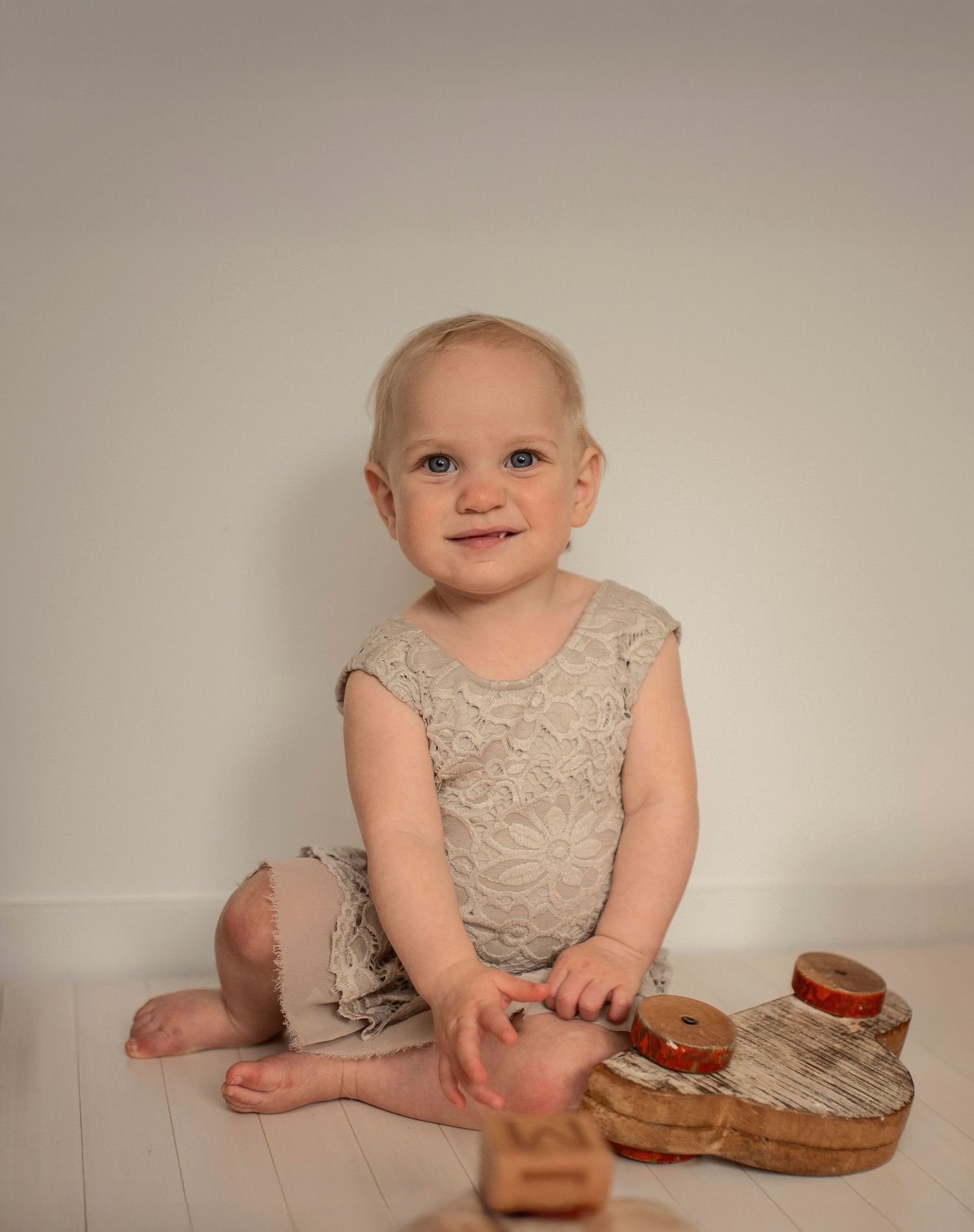 Ettårsfotografering i Hässleholm med ett barn i spetsklänning 
 i bohemisk studiomiljö