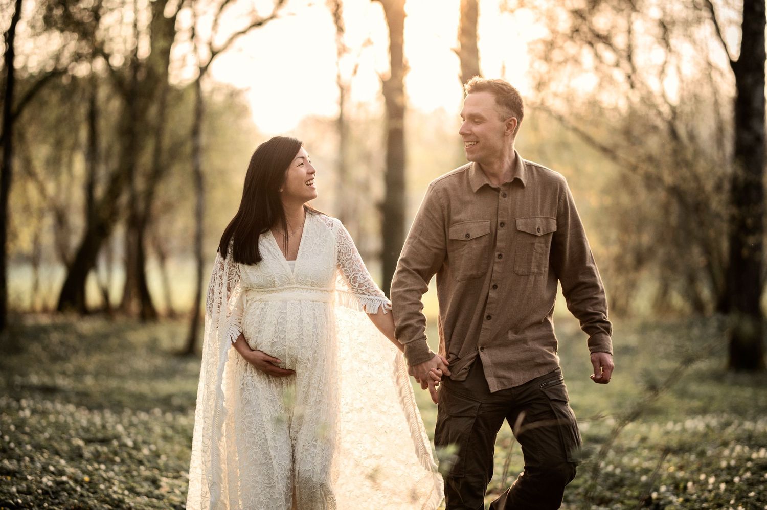 Gravid kvinna och hennes partner delar en kärleksfull stund under en gravidfotografering i skogen.
