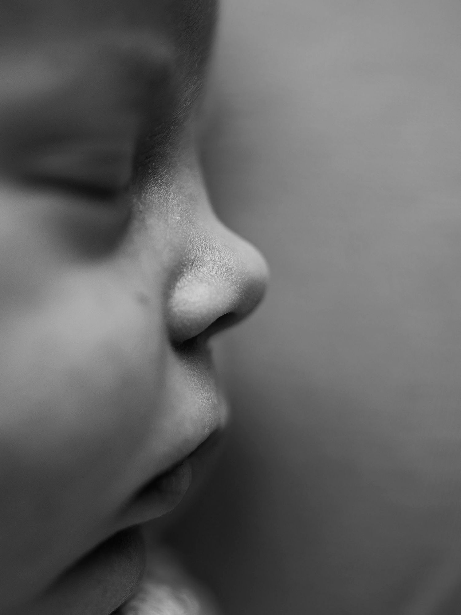 Svartvit närbild av en sovande nyfödd bebis under en nyföddfotografering i Hässleholm.