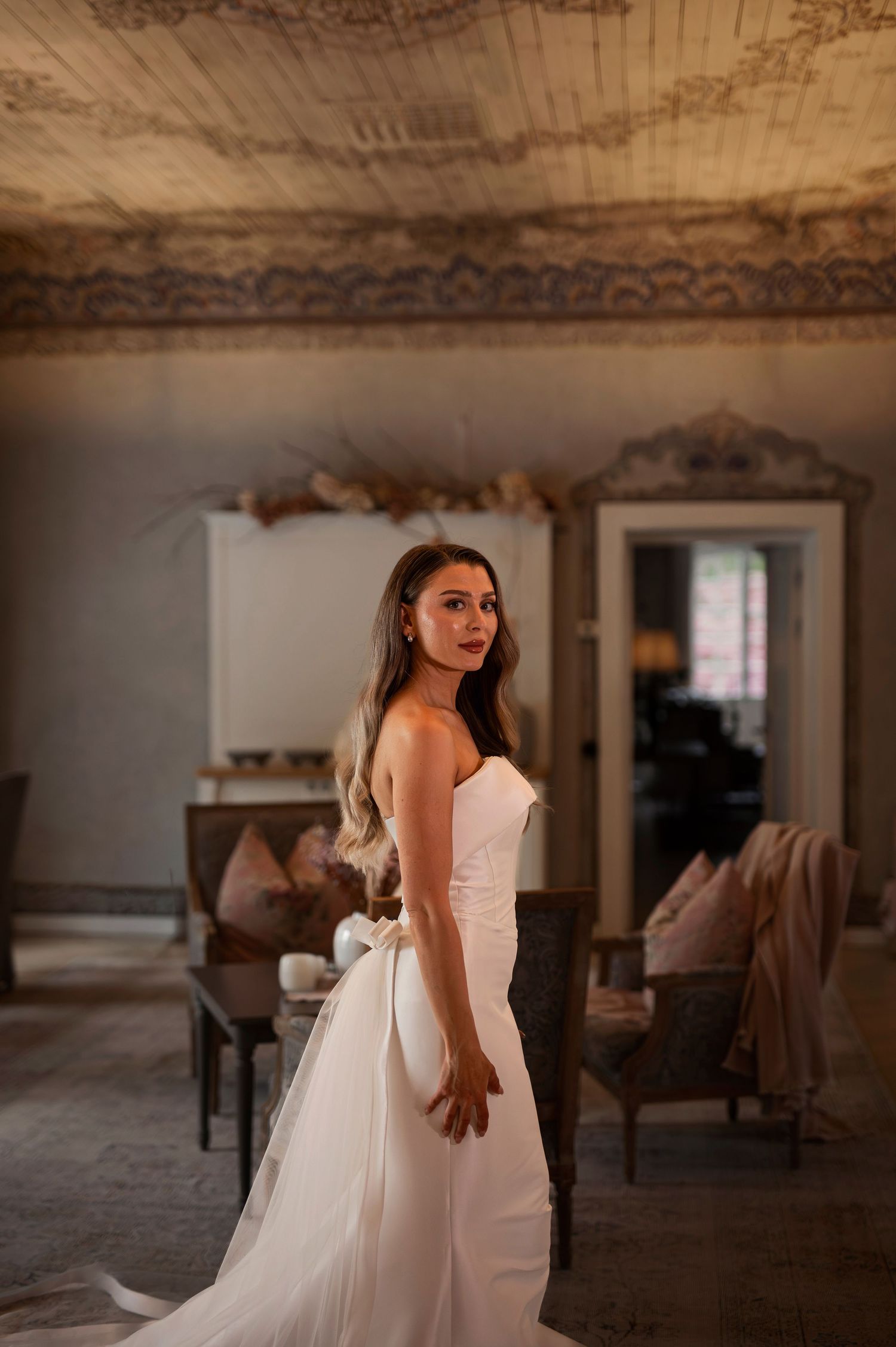 Bröllopsfotografering på Norrviken i Skåne med brud i elegant klänning i utsmyckat vintage rum.