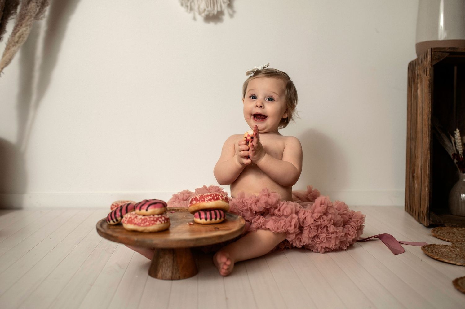 Ettårsfotografering i Hässleholm med en leende flicka bredvid allergivänliga munkar under en smash the cake-session.