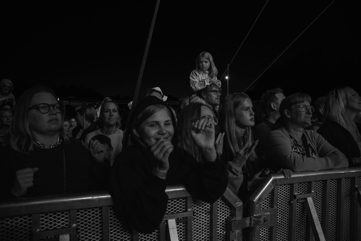 Konsertfotografering i Skåne med publik som ser en livekonsert i svartvitt nattljus.
