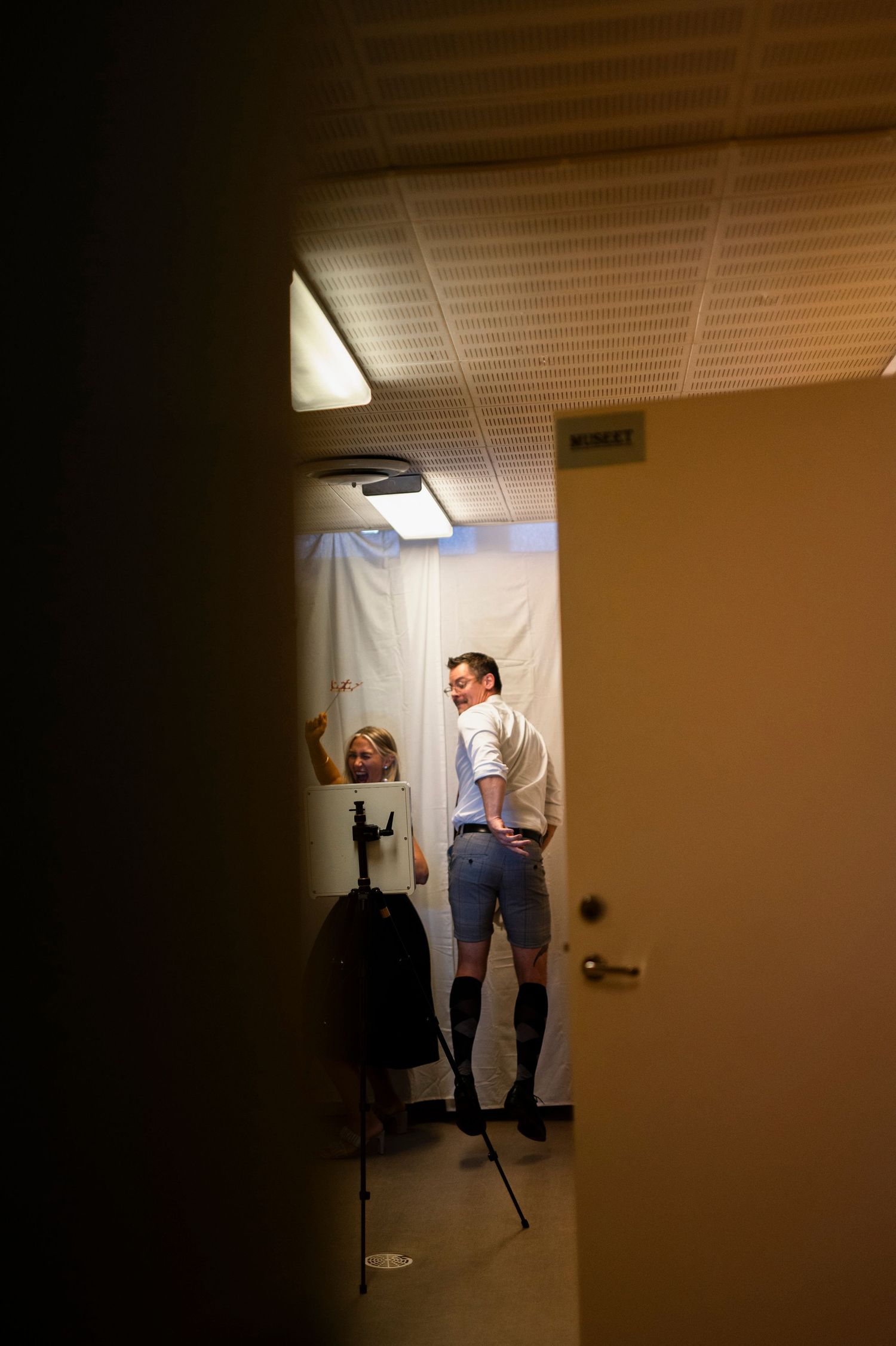 Bröllopsfotografering i Skåne med brudgum i festlokal i mjukt stämningsfullt ljus.