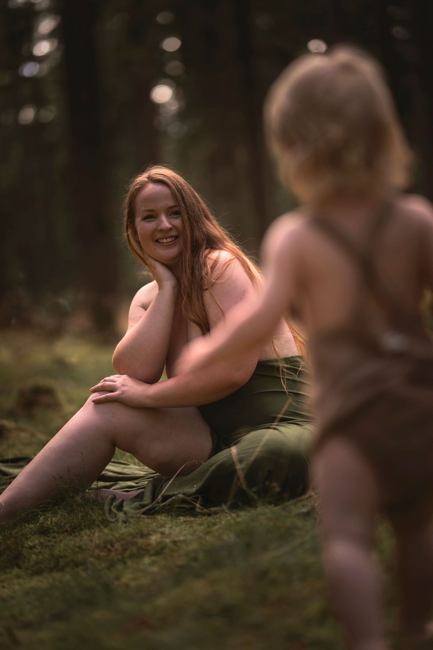familjefotografering i Skåne med intimt ögonblick mellan förälder och barn i skogsmiljö.