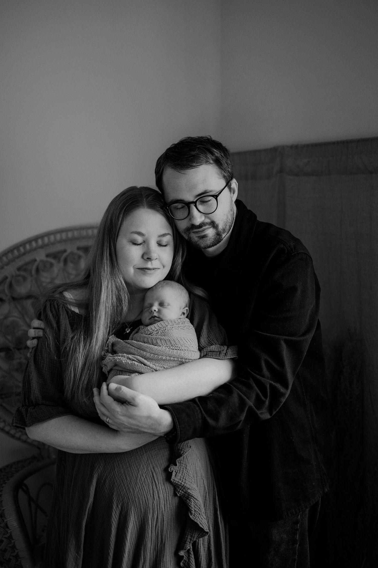 Svartvit nyföddfotografering i Hässleholm med nyblivna föräldrar och deras sovande bebis.