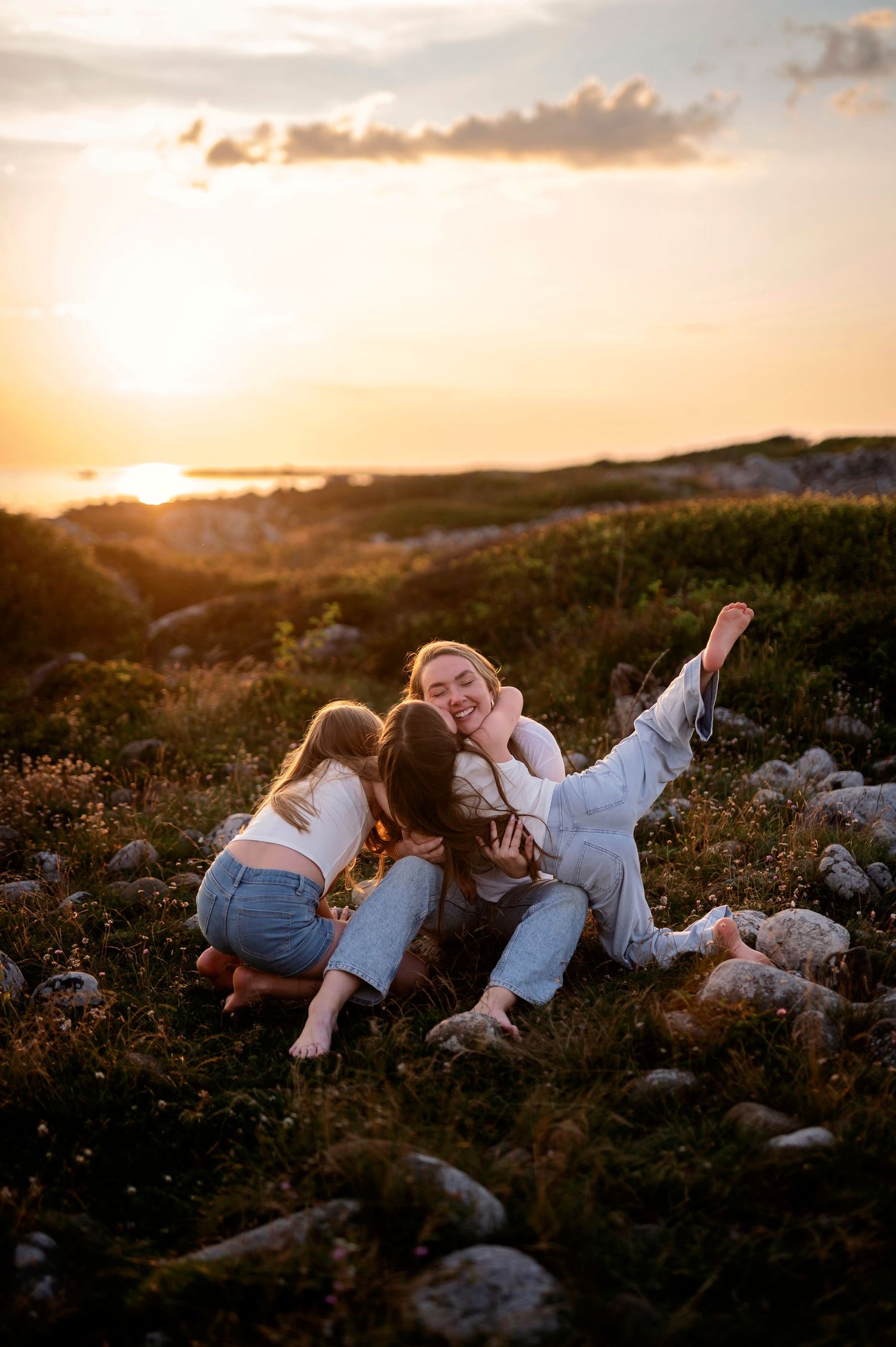 Tre kvinnor fotograferade vid havet i Varberg under en familje- eller generationsfotografering i gyllene kvällsljus.