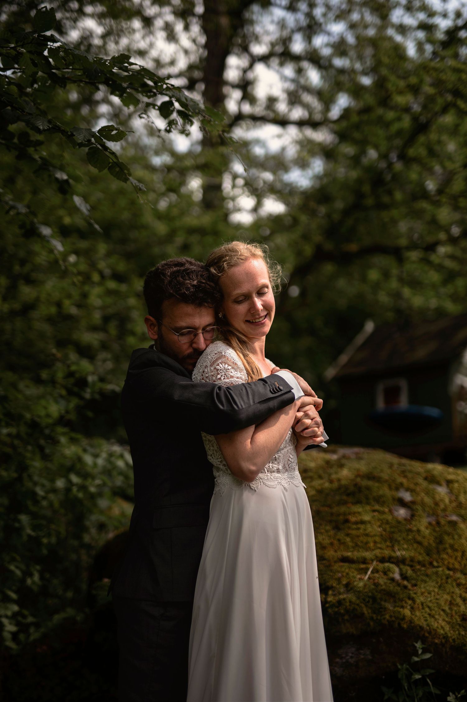 Bröllopsfotografering i Skåne med brudpar i omfamning i grönskande natur utomhus.