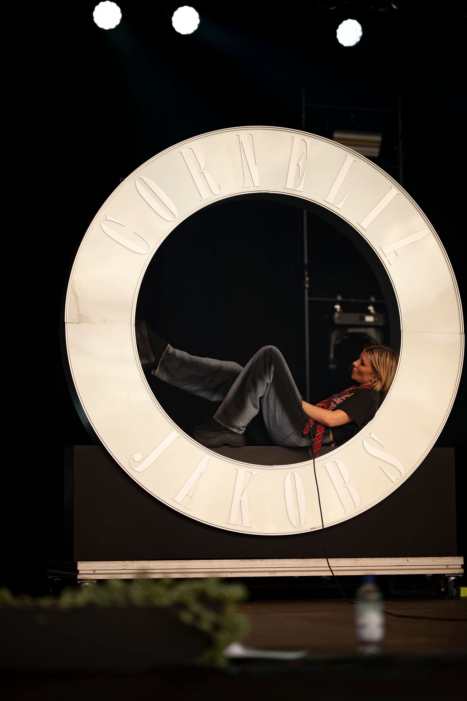 Konsertfotografering i Skåne med artist i ljussatt cirkelscen i mörk venue.