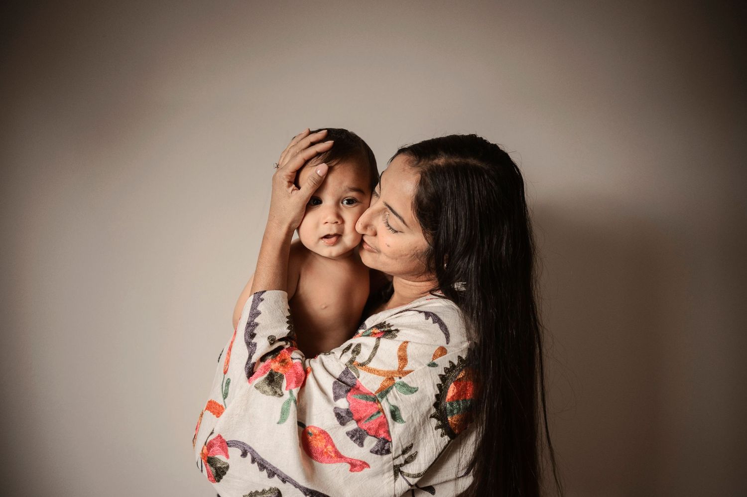 Familjefotografering i Hässleholm med mamma och barn i ljus och luftig studiomiljö.