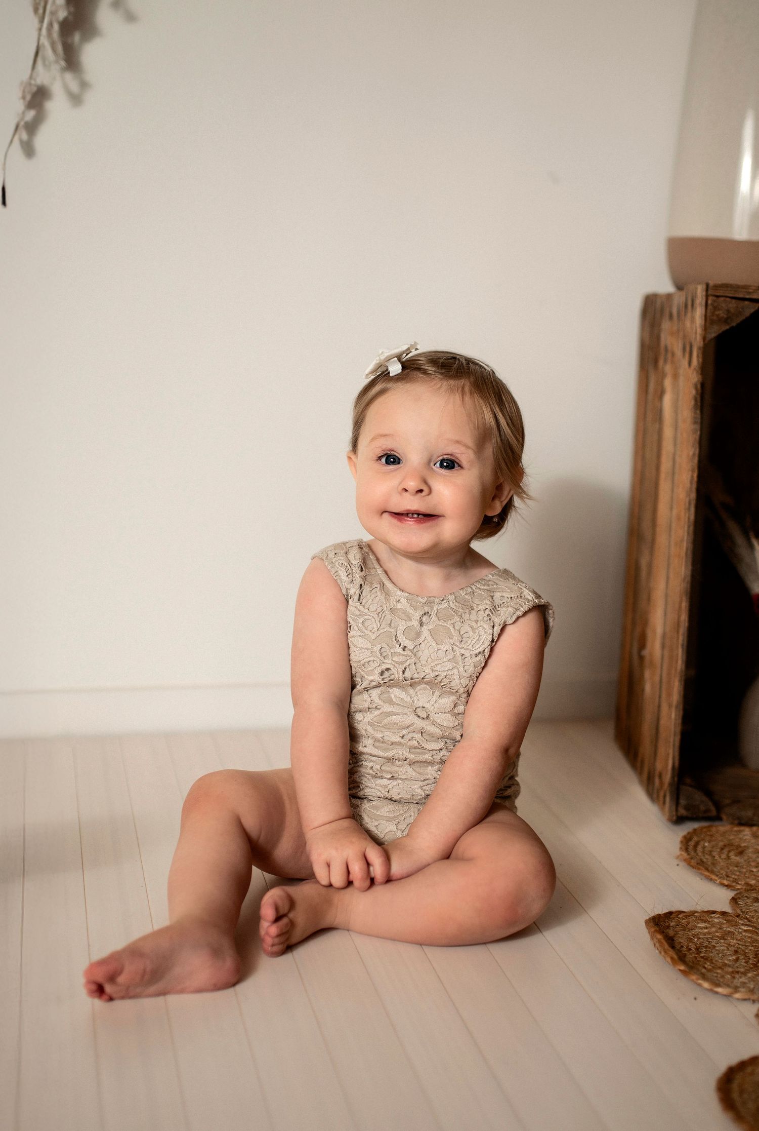 Leende bebis på gunghäst under en barnfotografering i studio i Hässleholm med bohemisk inredning.