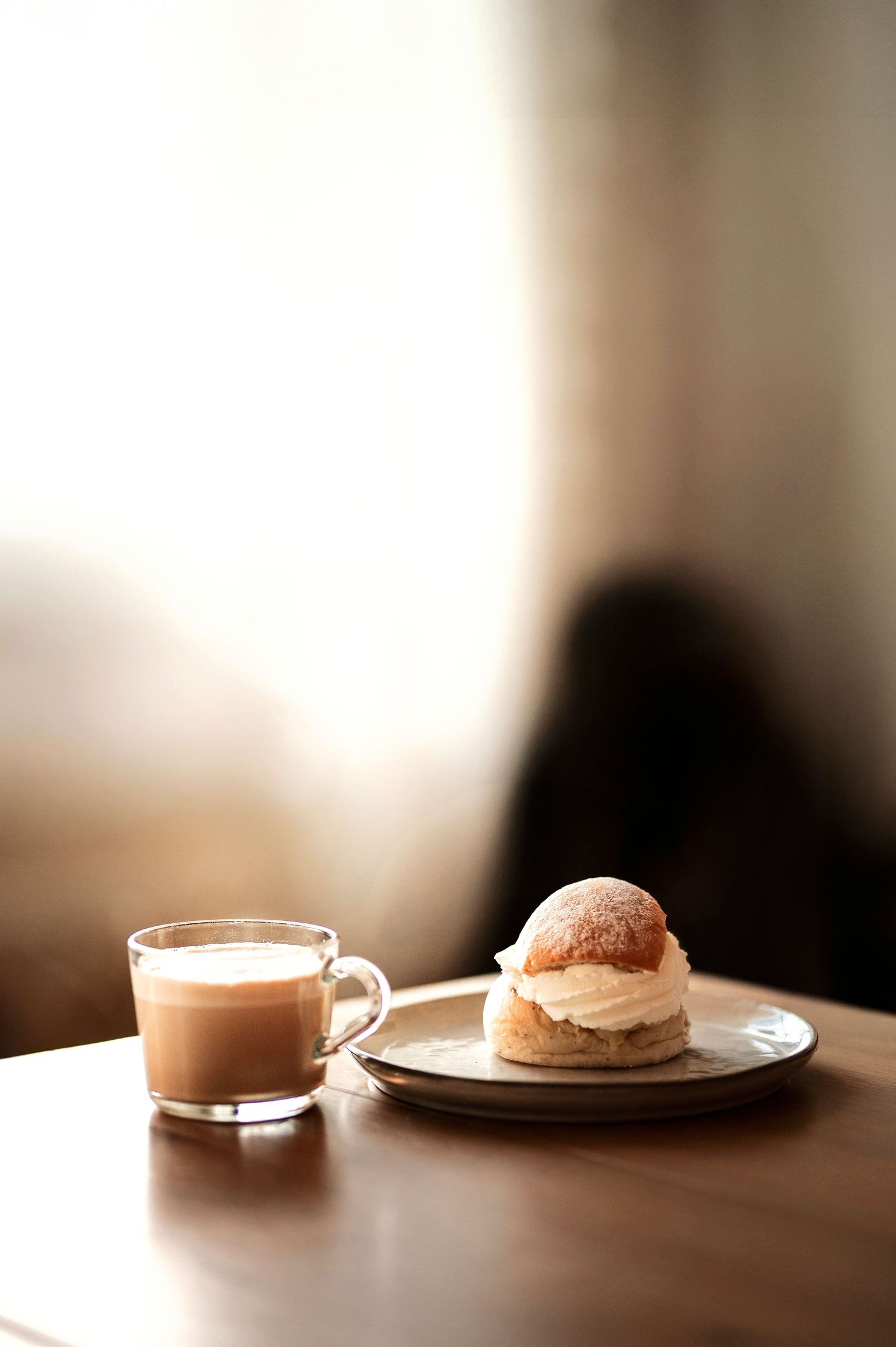 Lifestyle företagsfoto i Skåne med semla och latte i varmt ljus på träbord