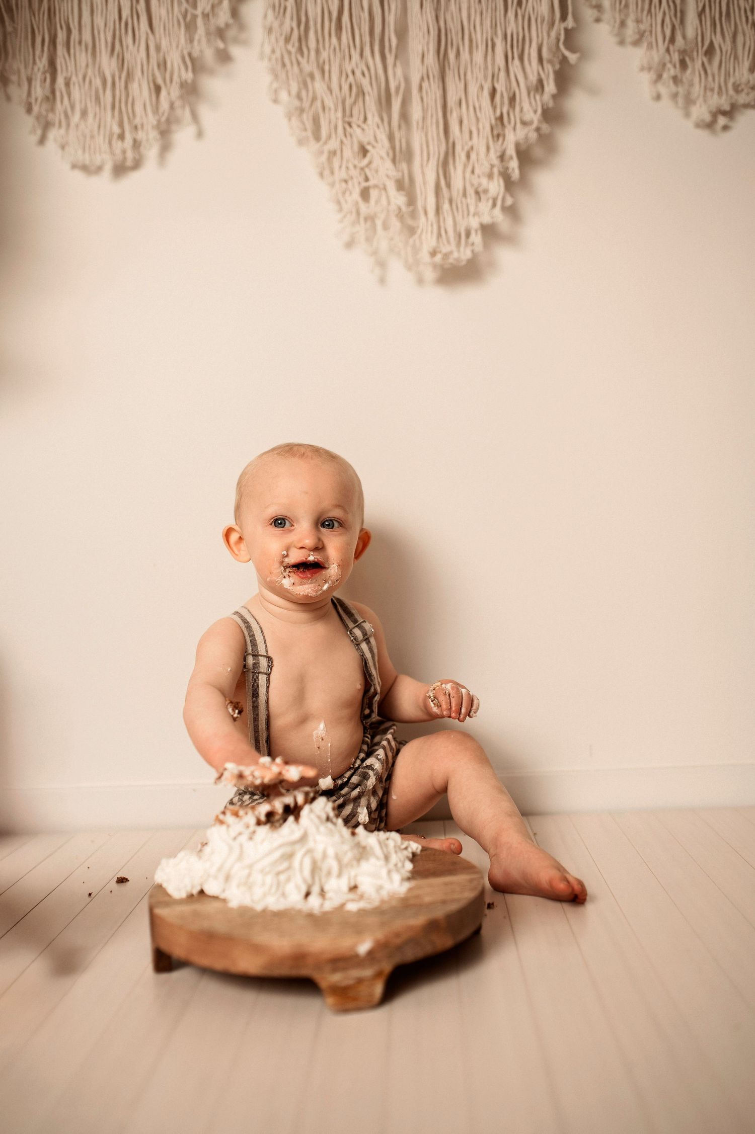 Ettårsfotografering i Hässleholm med bebis som äter tårta i en smash the cake-session inomhus.
