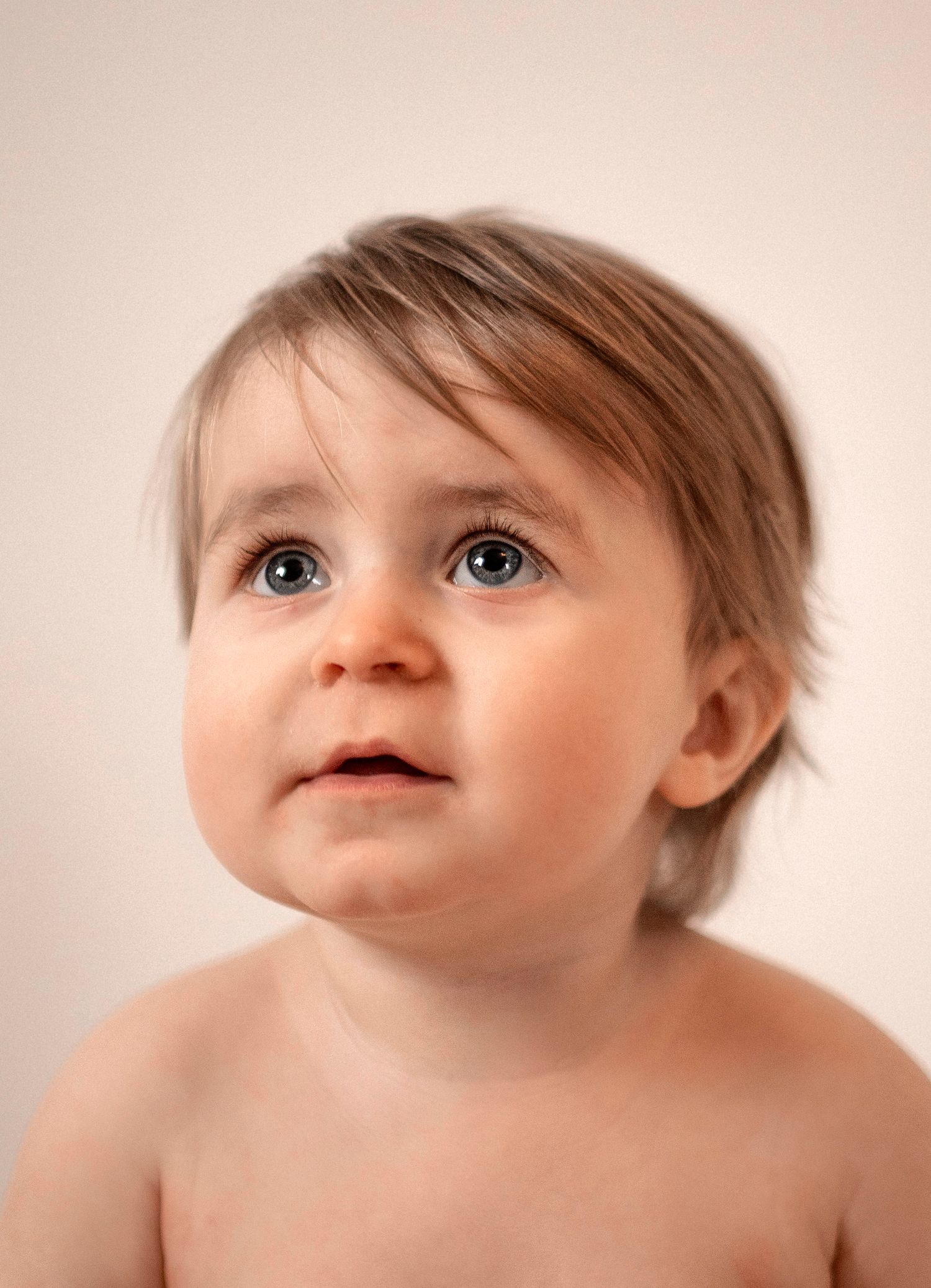 Närporträtt av en nyfiken bebis under en barnfotografering i studio i Hässleholm.