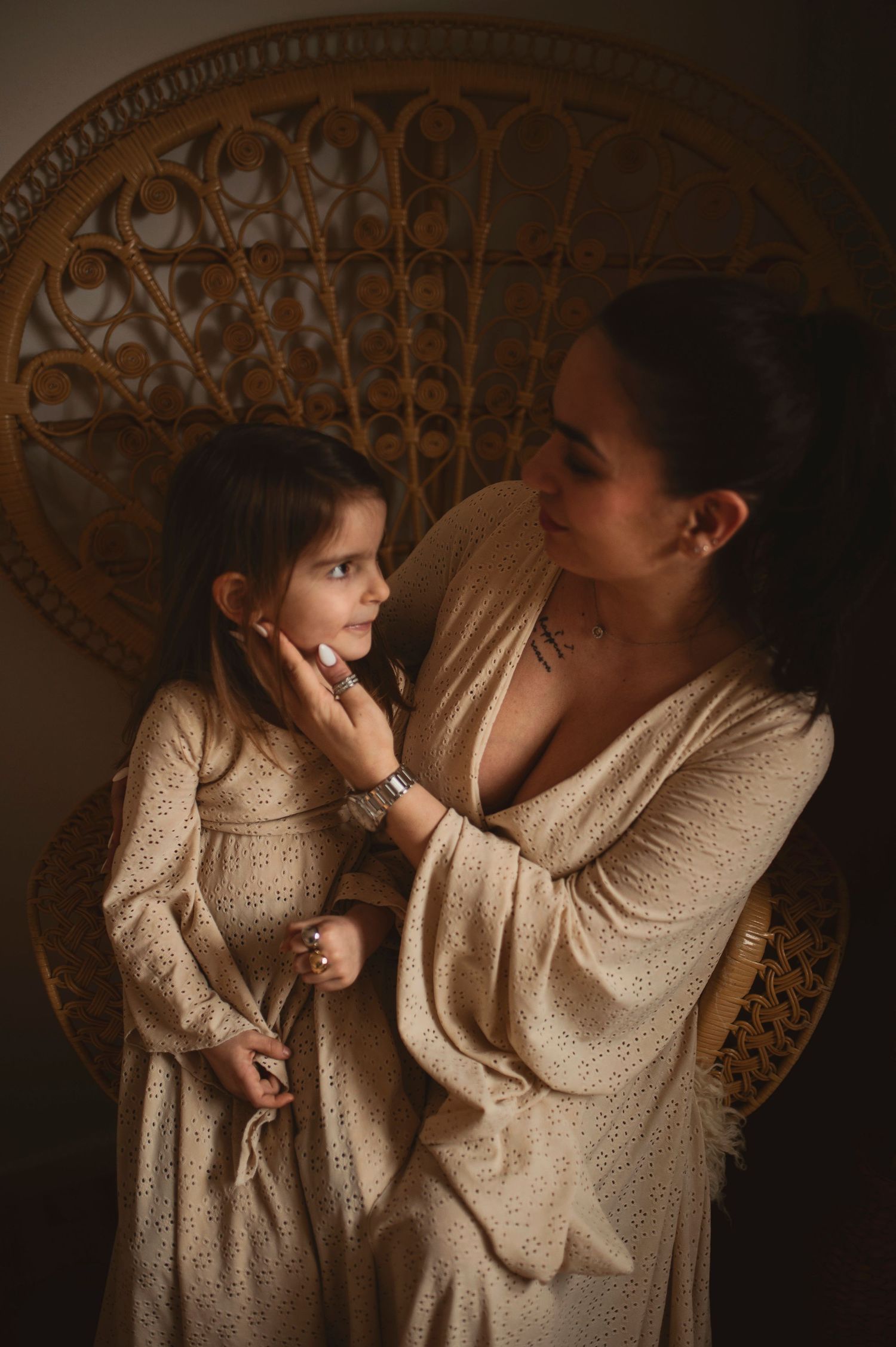 Intimate portrait features two people in matching cream knit dresses against vintage decor.