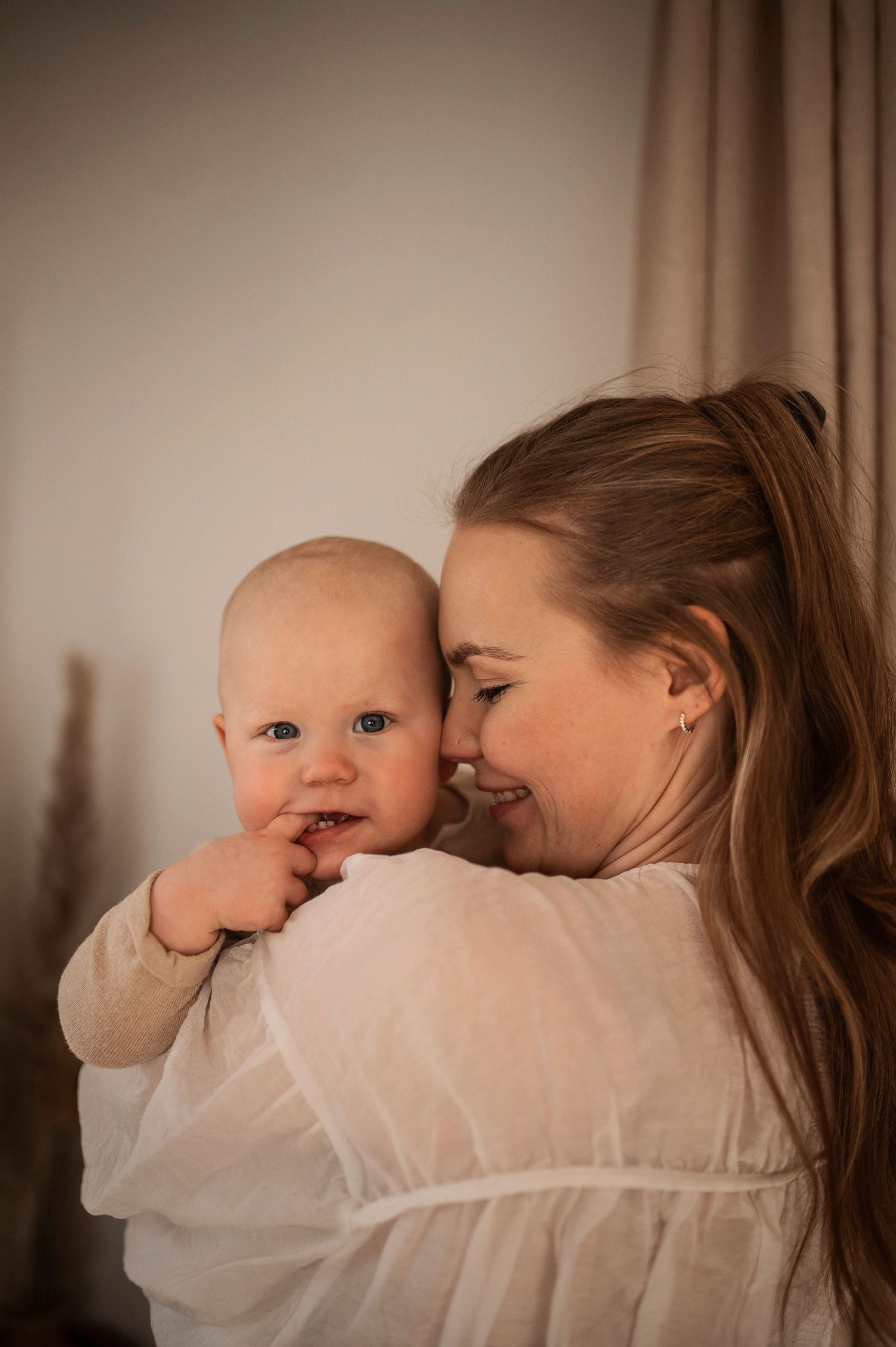 Förälder och bebis delar en glad stund under en familjefotografering i Hässleholm.