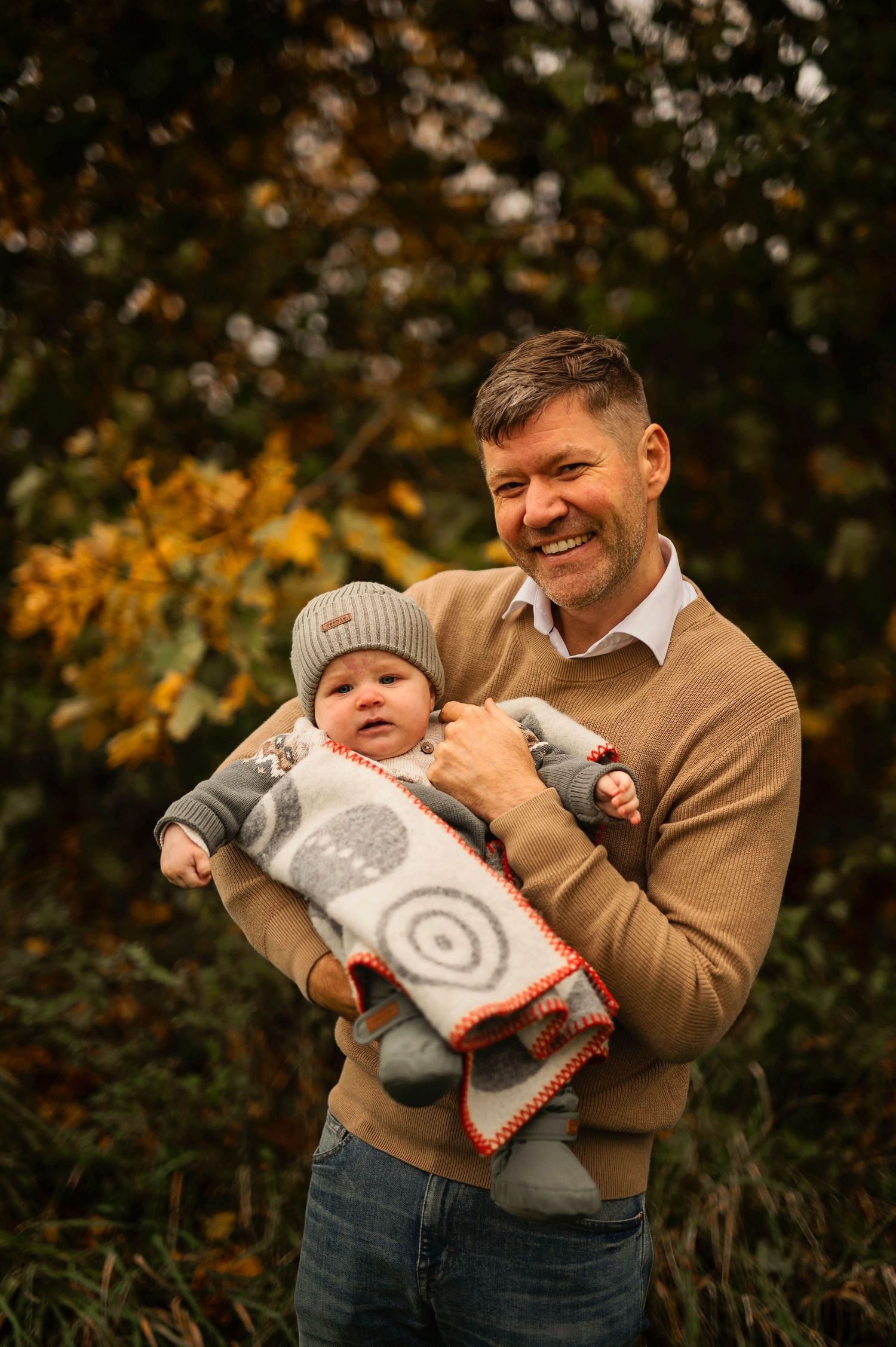 A joyful moment captured between parent and baby in cozy fall sweaters.