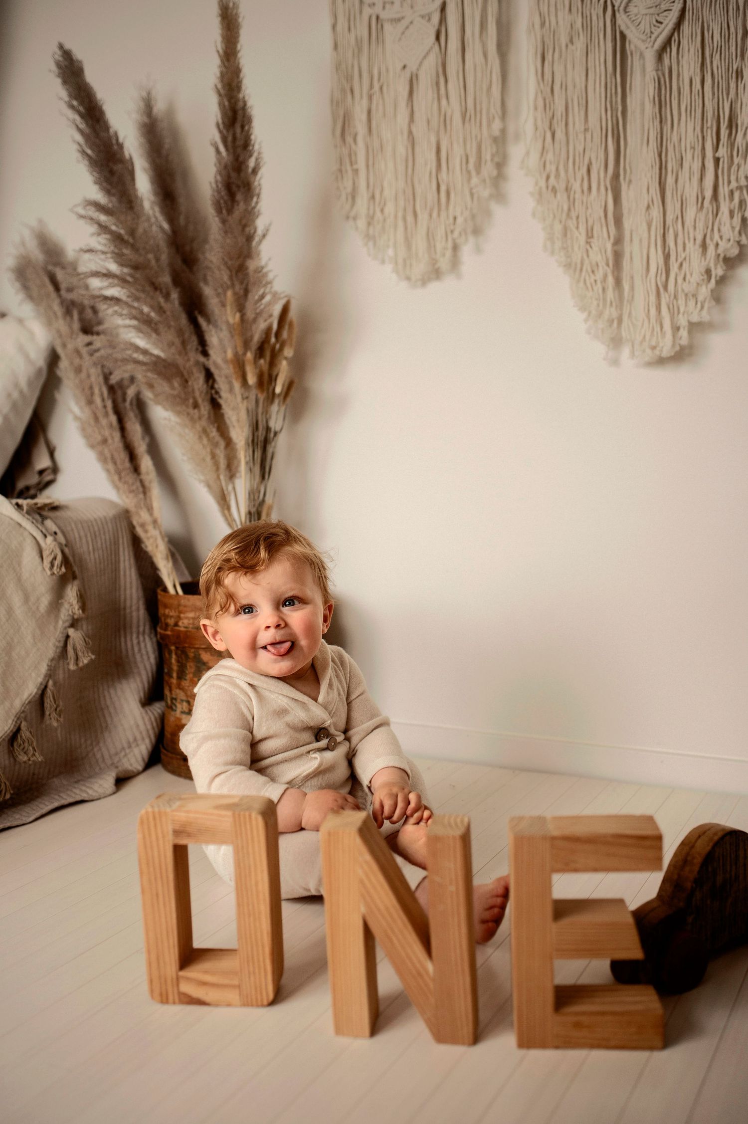 Smash the cake-fotografering i studio i Hässleholm med bebis och födelsedagstårta framför makramévägg