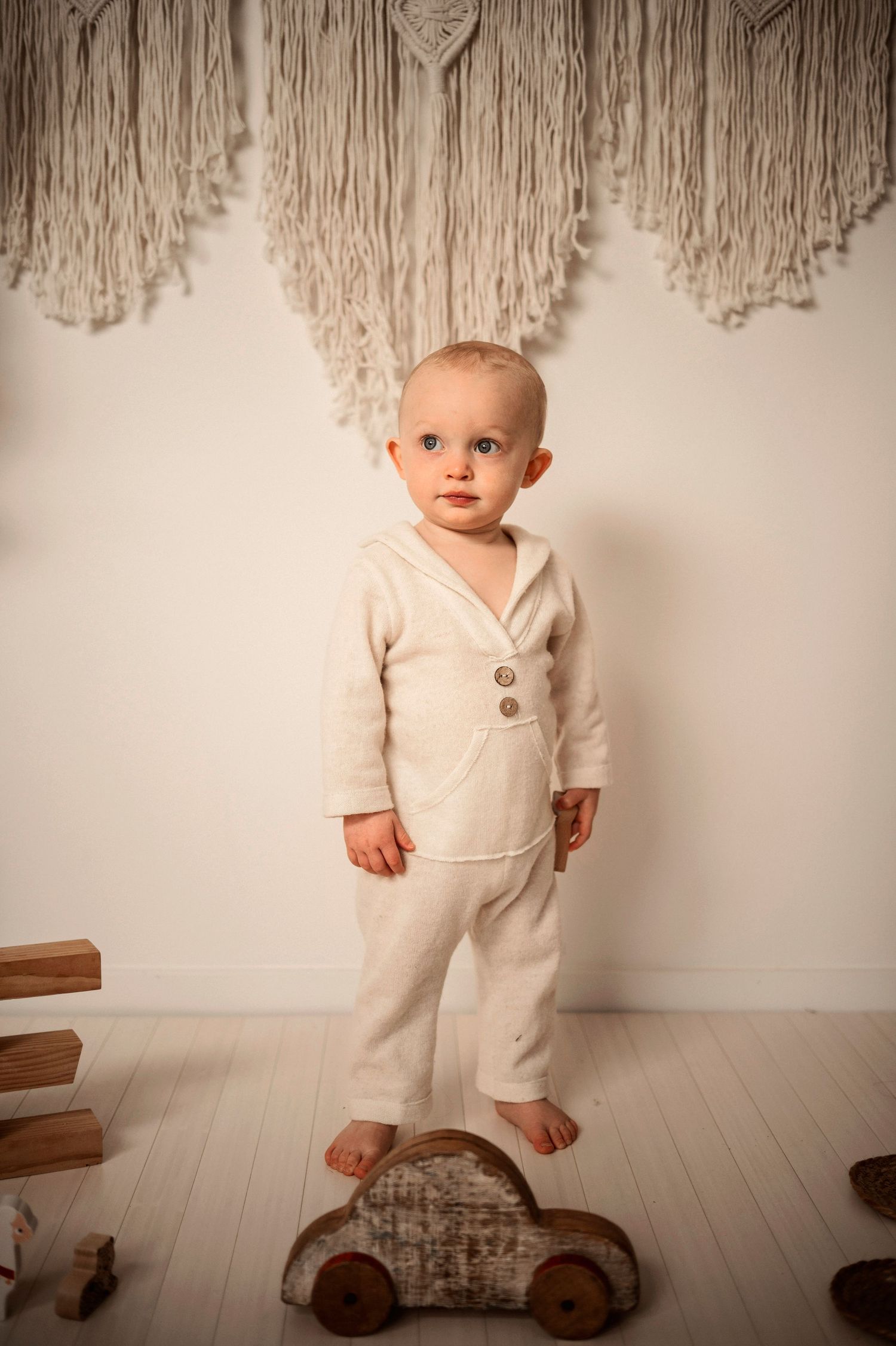 Barnfotografering i Hässleholm med ett barn i boho-studiomiljö i cream-toner.