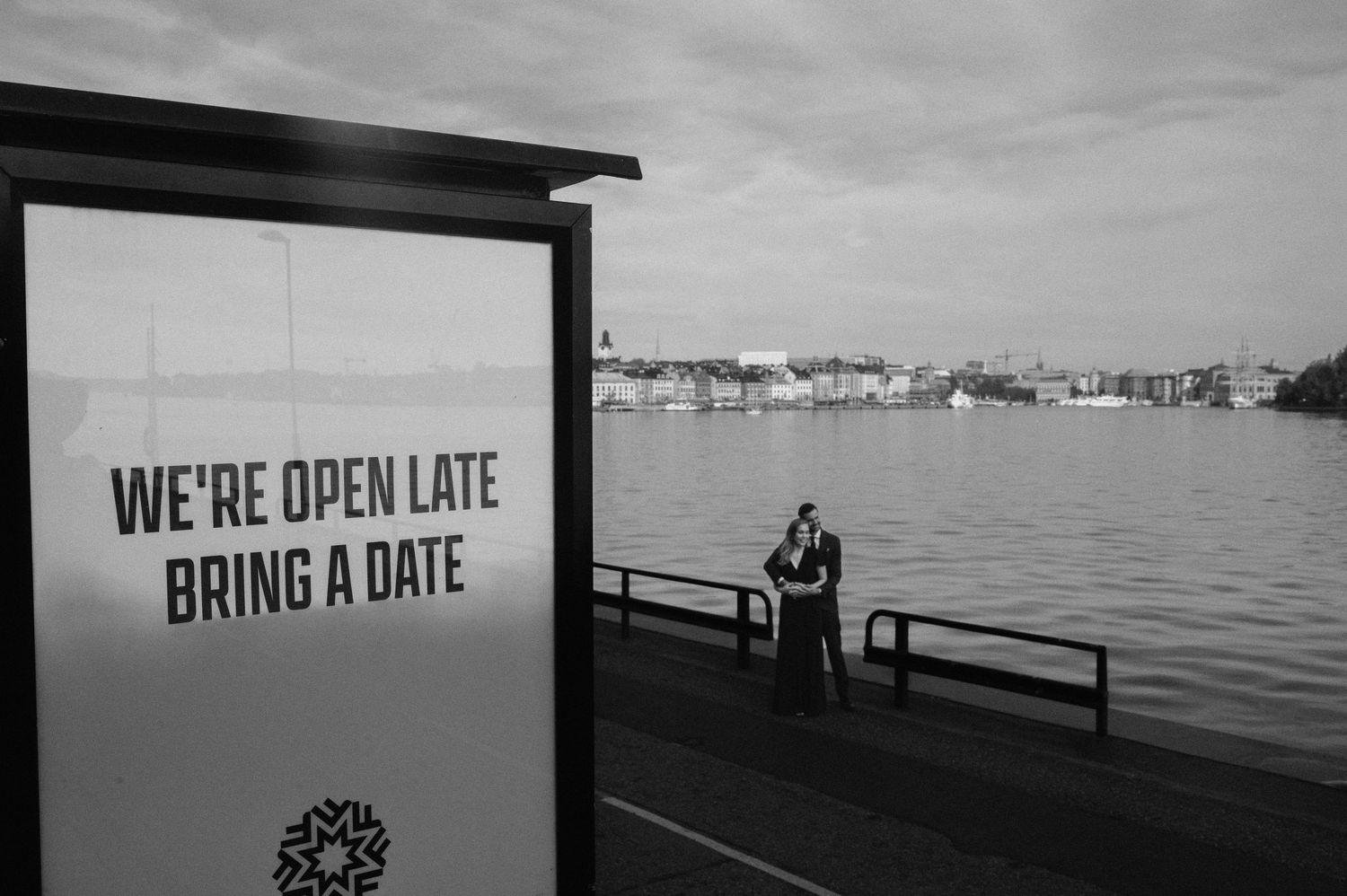 Parfotografering i Stockholm vid Fotografiska med omfamning vid vatten i urban miljö.
