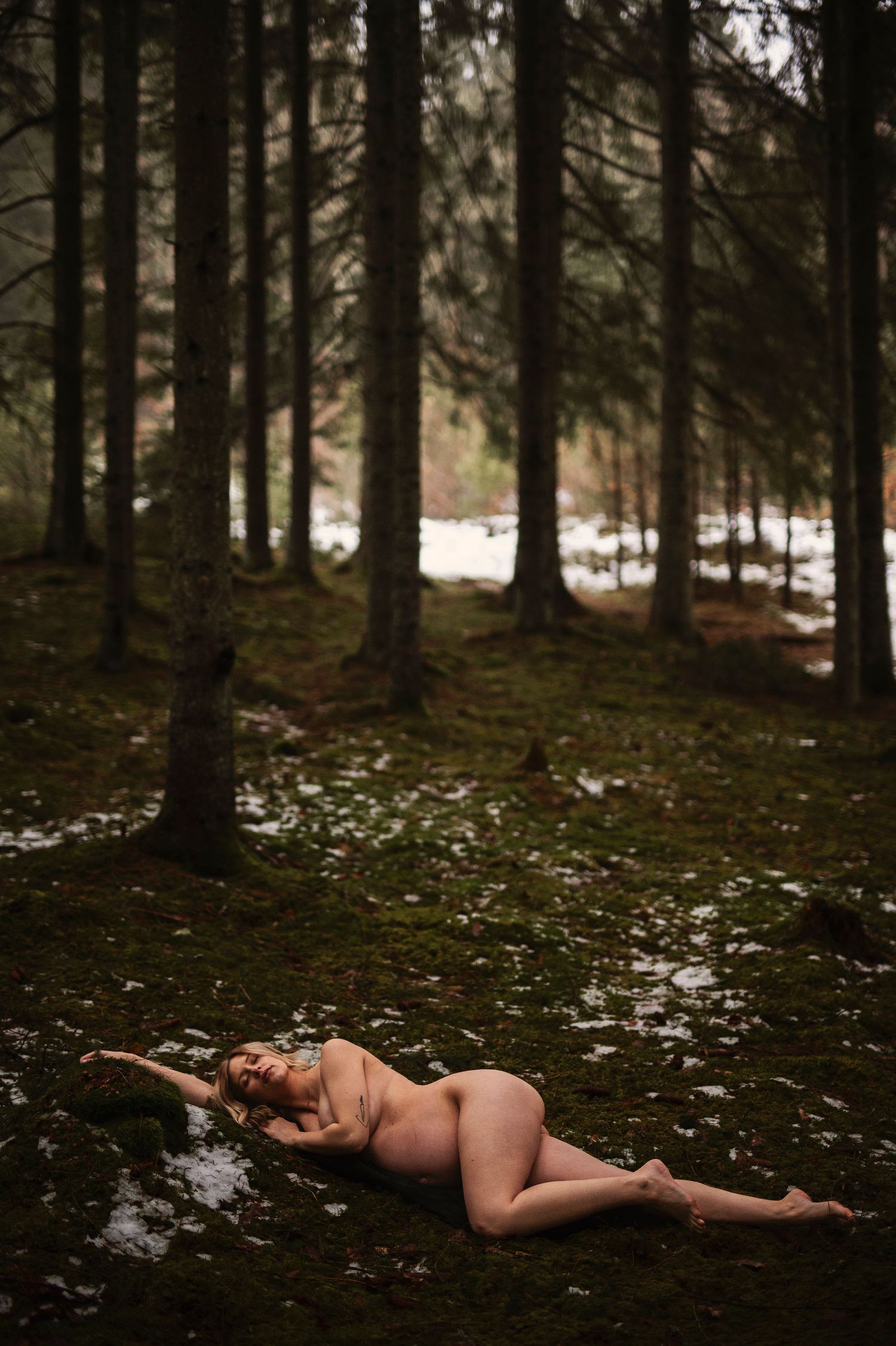 Gravidfotografering i Skåne med konstnärligt svartvitt porträtt av gravid kvinna i skogsmiljö.
