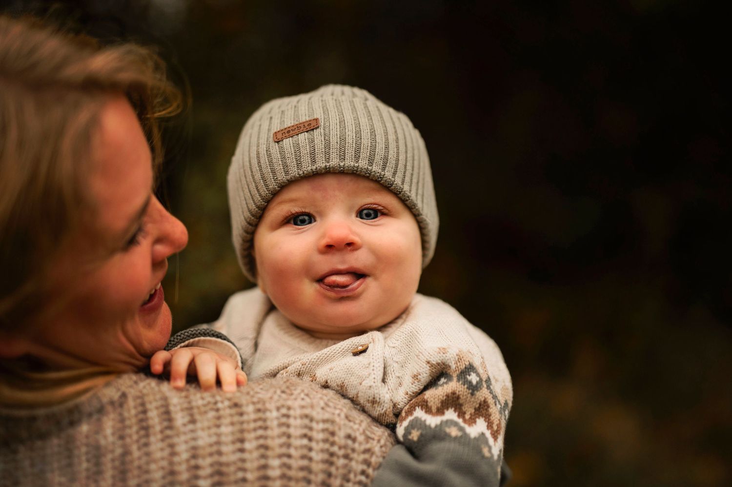 Sweet moment captured outdoors with cozy winter attire and natural lighting.