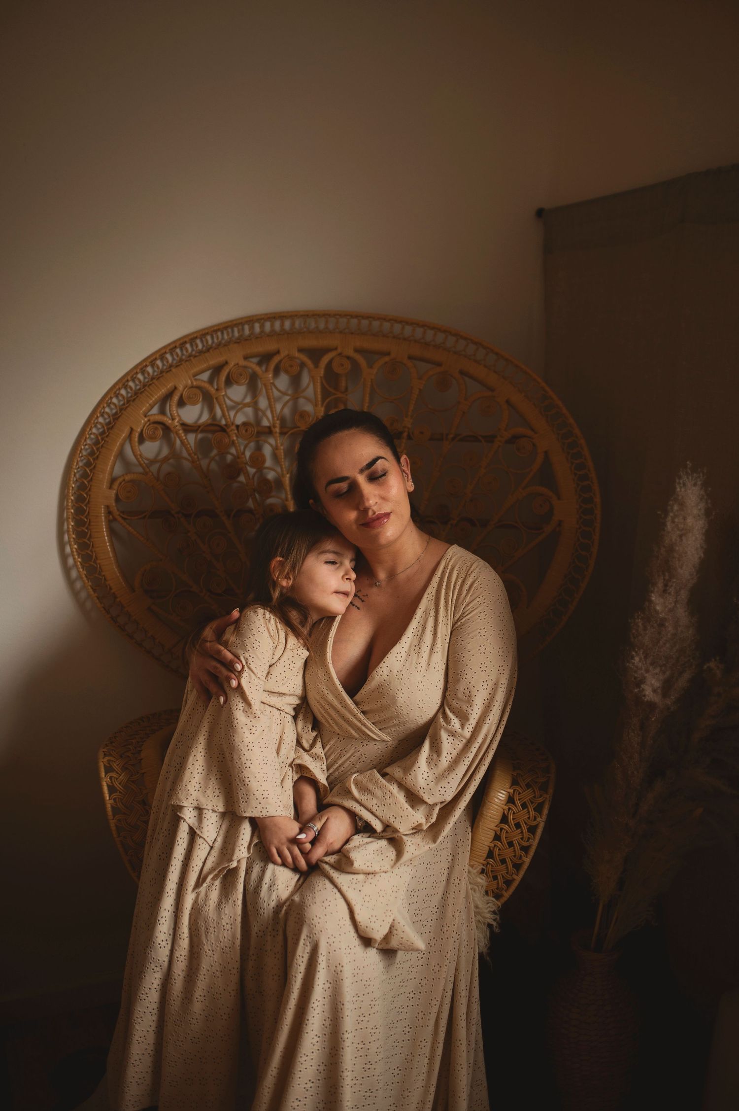 Intimate moment captured between two people in cream dresses against vintage backdrop.