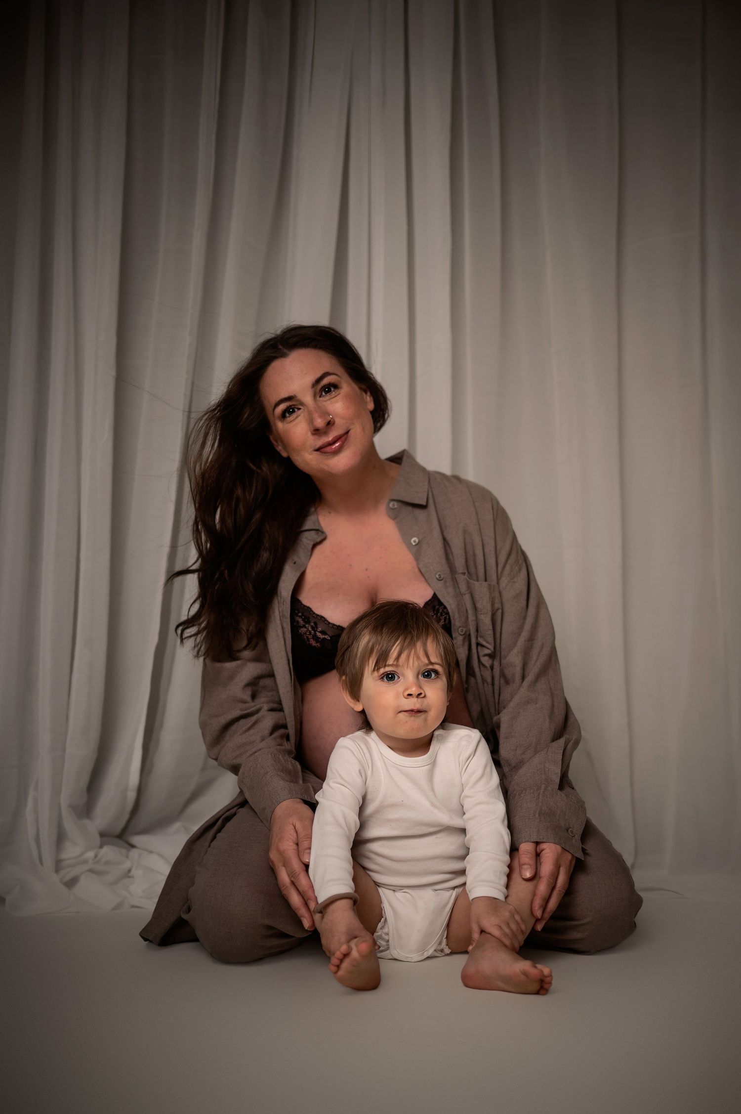 Gravidfotografering i Hässleholm med mamma och barn i mjukt studioljus.