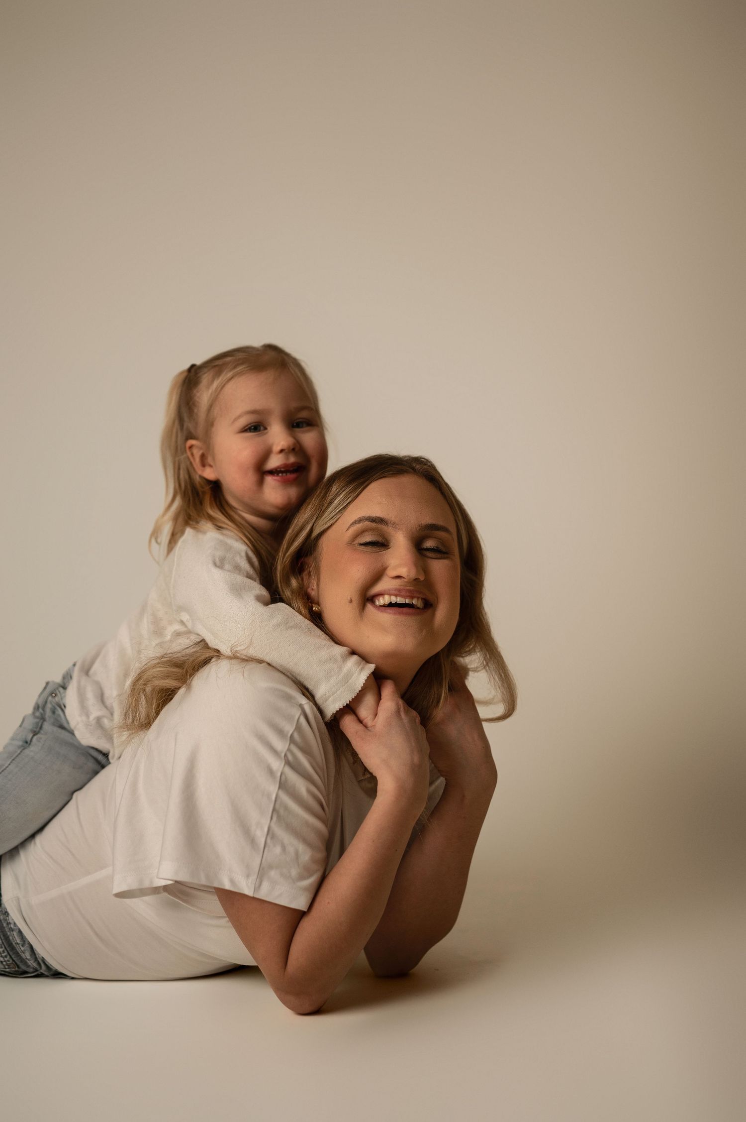 Familjefotografering i Hässleholm med mamma och barn i lekfull och kärleksfull stund i studio.