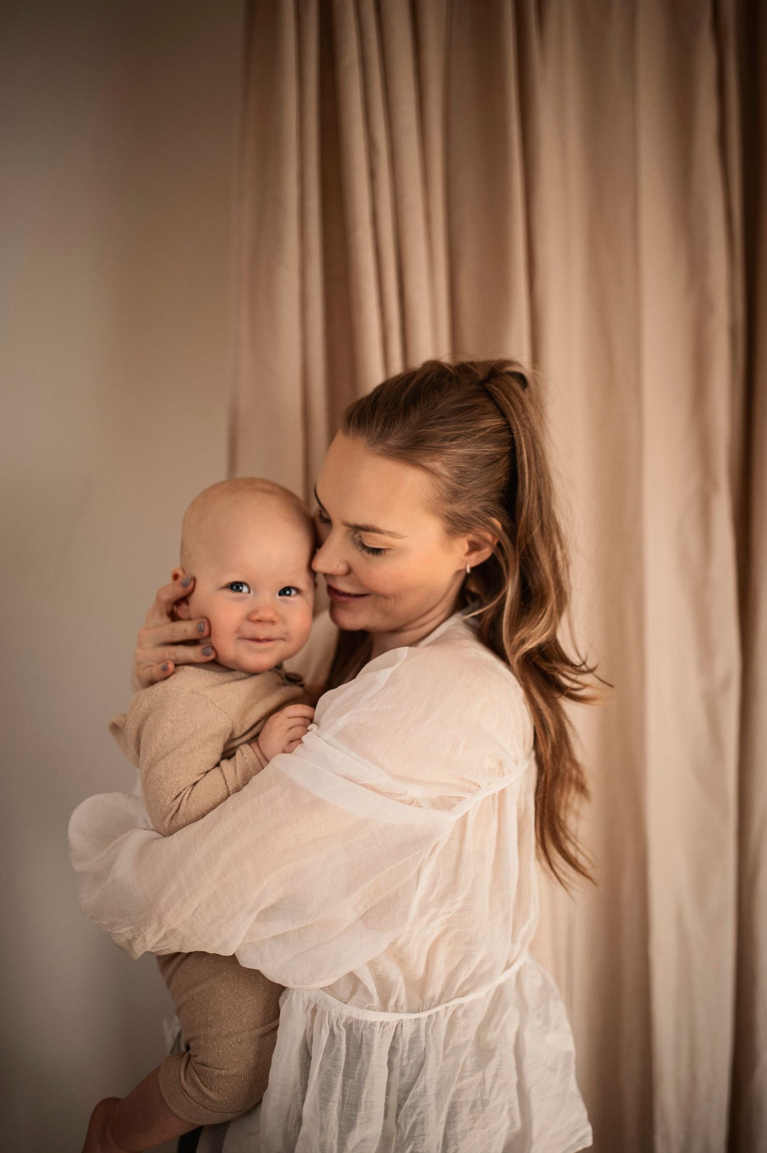 Förälder och bebis delar en glad stund under en familjefotografering i Hässleholm.