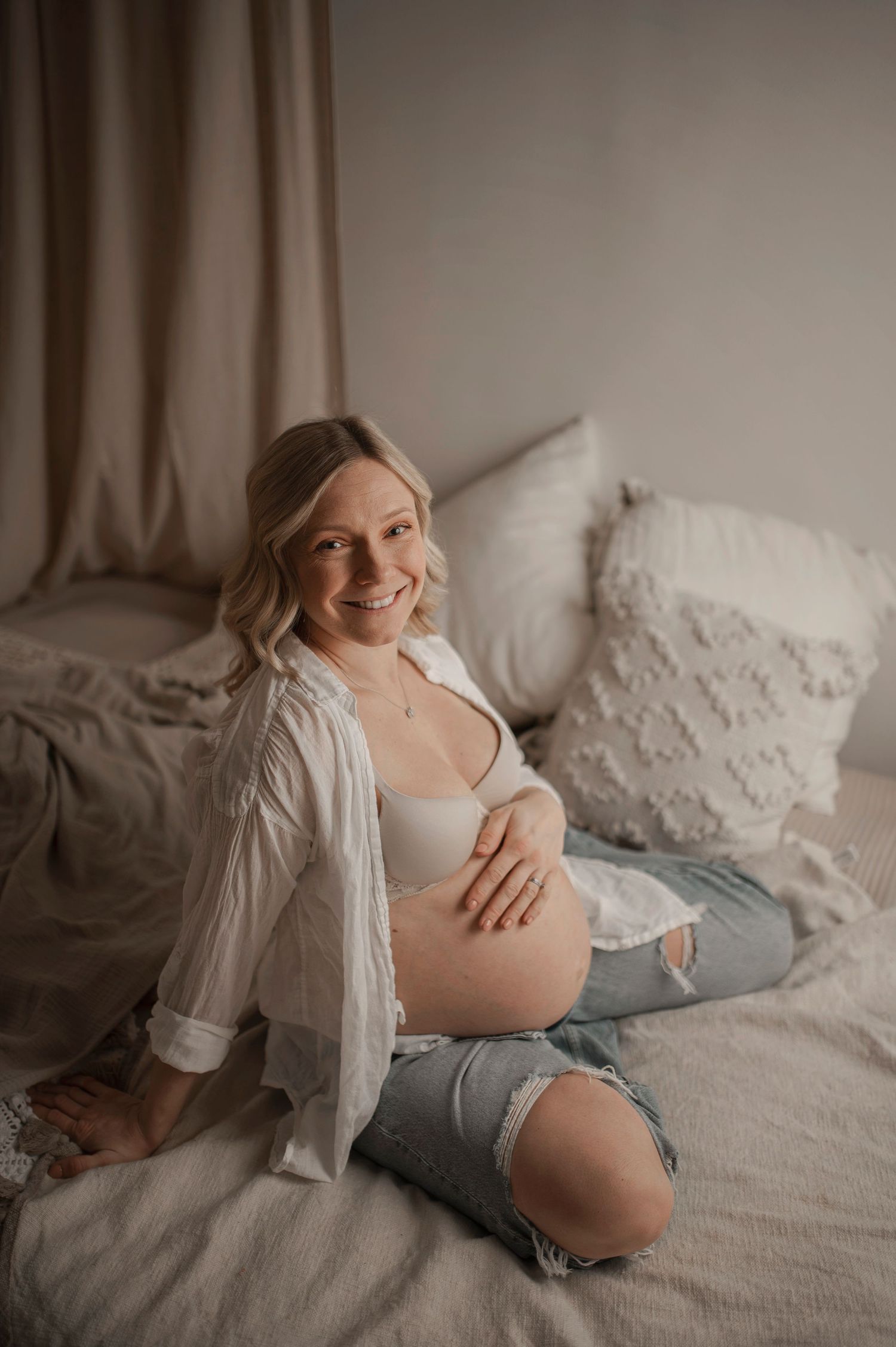 Gravid kvinna fotograferad i hemmalik miljö under en gravidfotografering i Hässleholm i naturligt ljus.