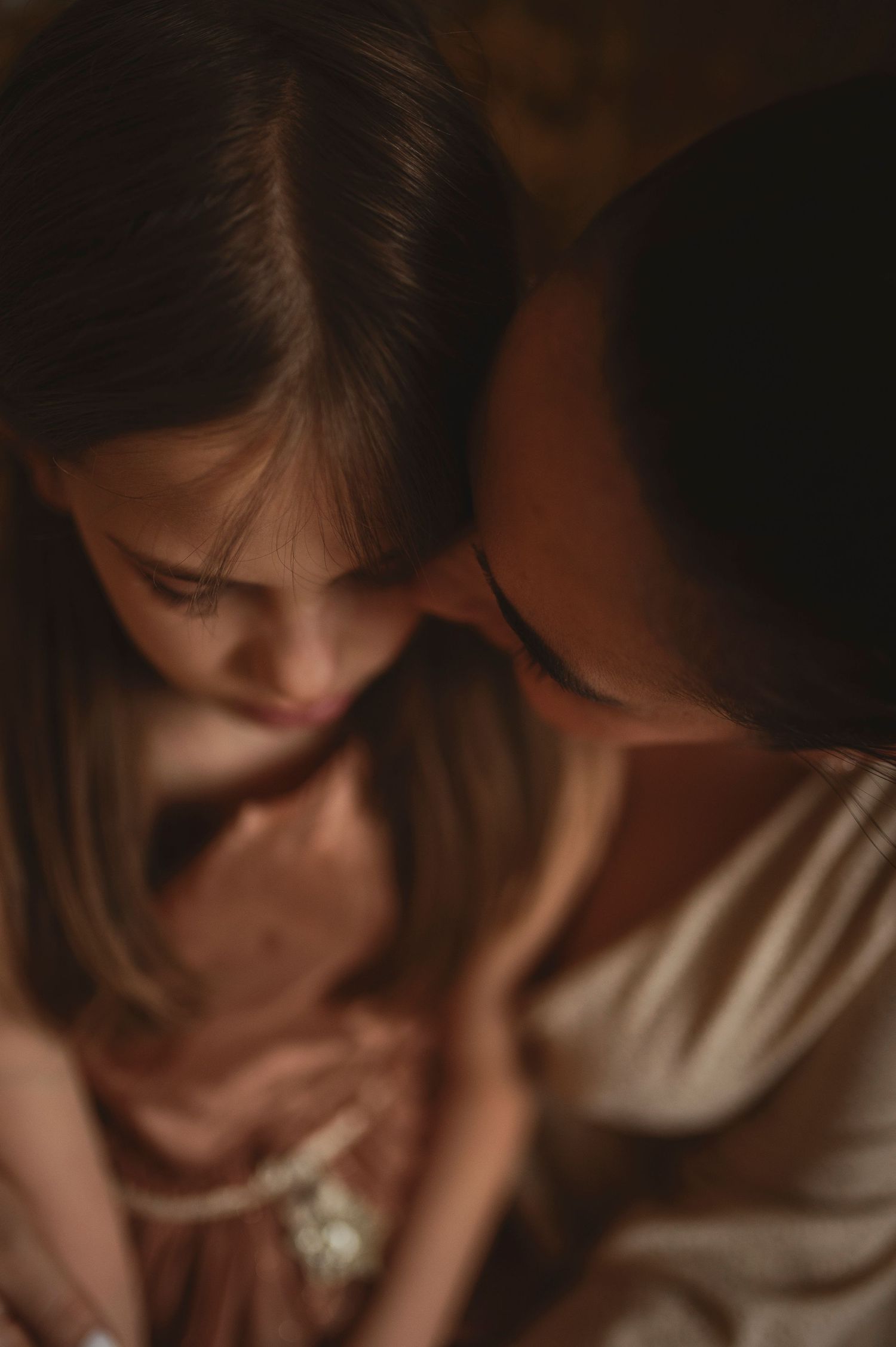 Intimate portrait in moody lighting showing closeness and connection.