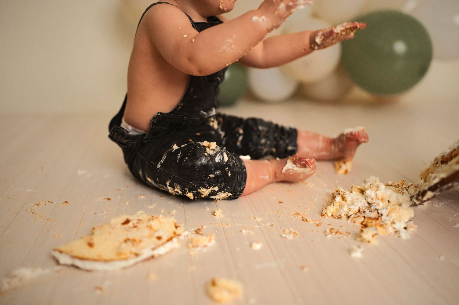A close-up shot of tiny feet covered in cake during a messy cake smash session.
