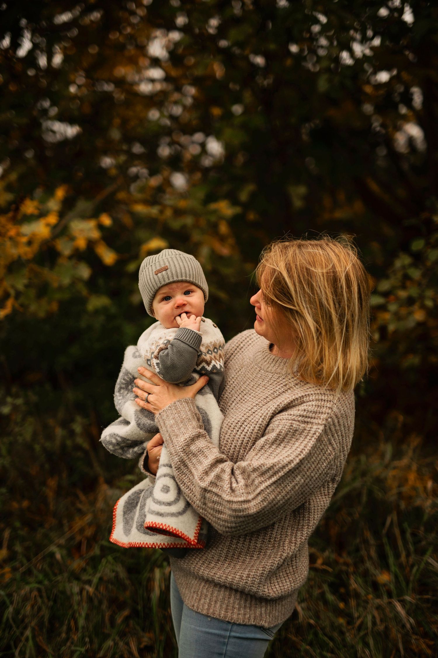 A tender moment between parent and baby wearing matching knit sweaters.