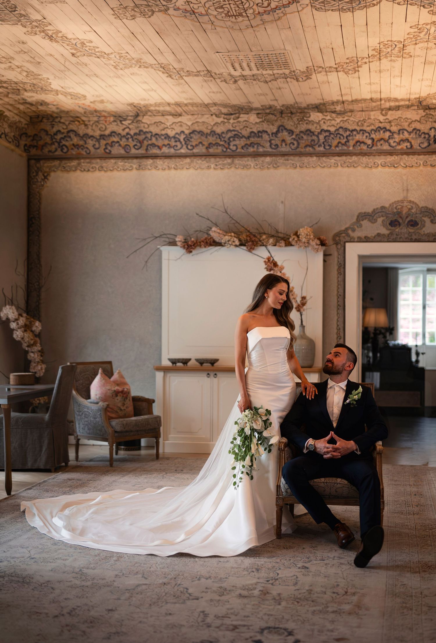 Bröllopsfotografering på Norrviken i Skåne med brudpar i elegant inomhusmiljö med dekorativt tak.