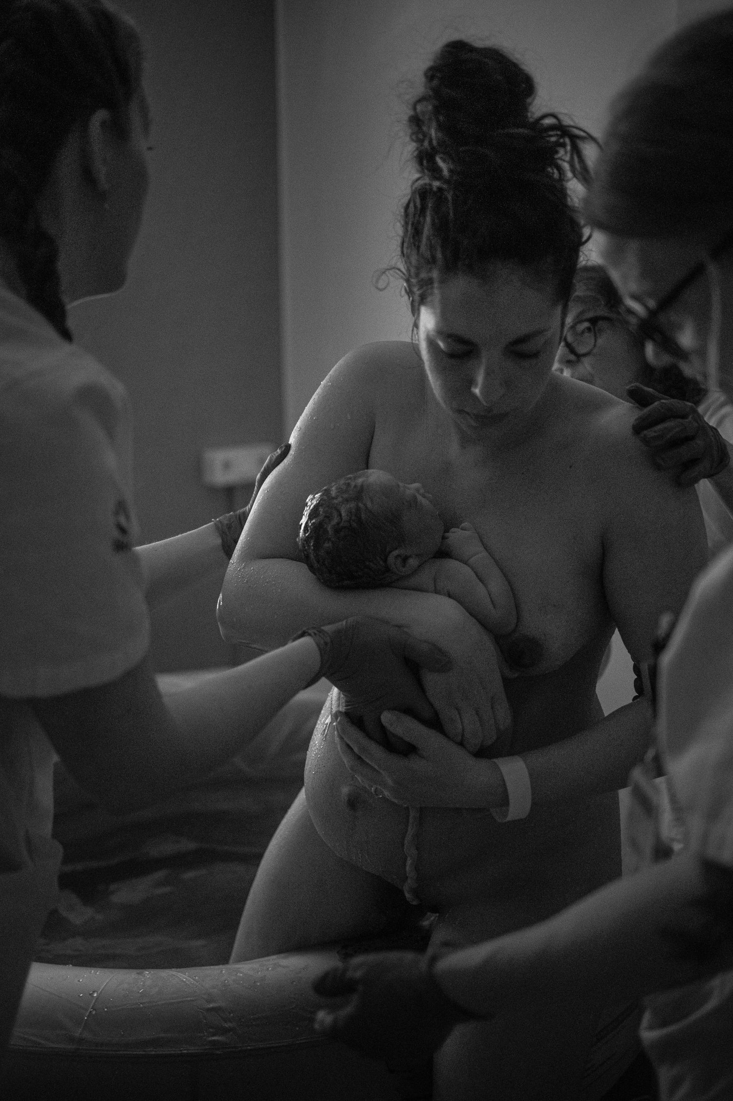 Black and white hospital scene with nurturing skin to skin contact with a newborn.