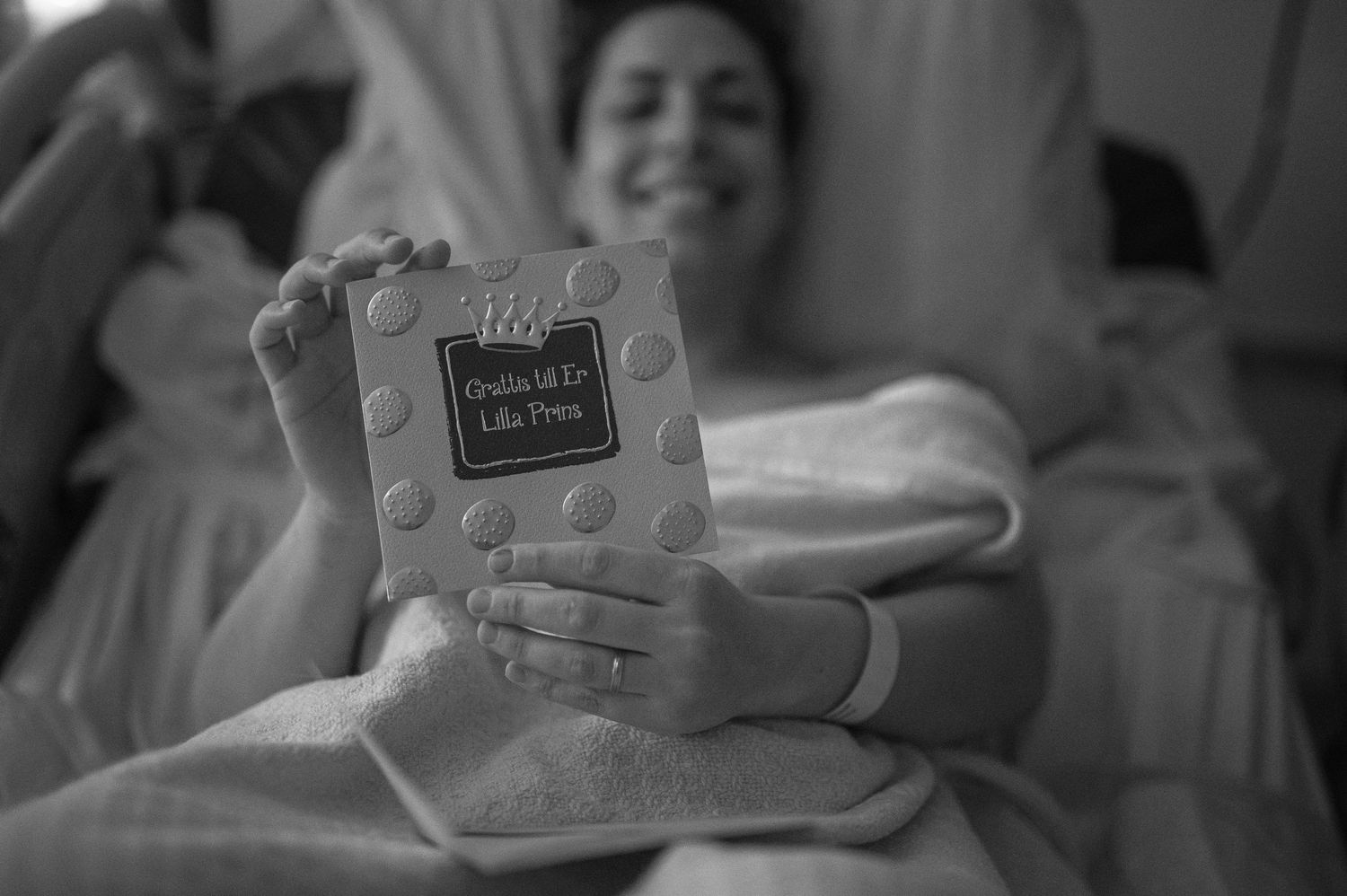 Svartvit förlossningsfotografering i Skåne med nybliven mamma i sjukhussäng efter födseln.
