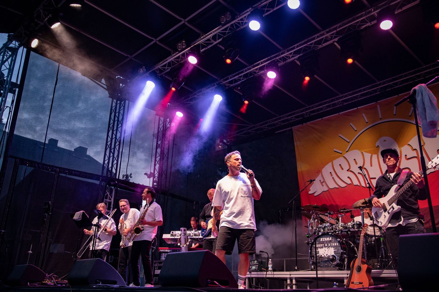 Eventfotografering i Skåne med rockband som spelar live på scen i färgstarkt konsertljus.