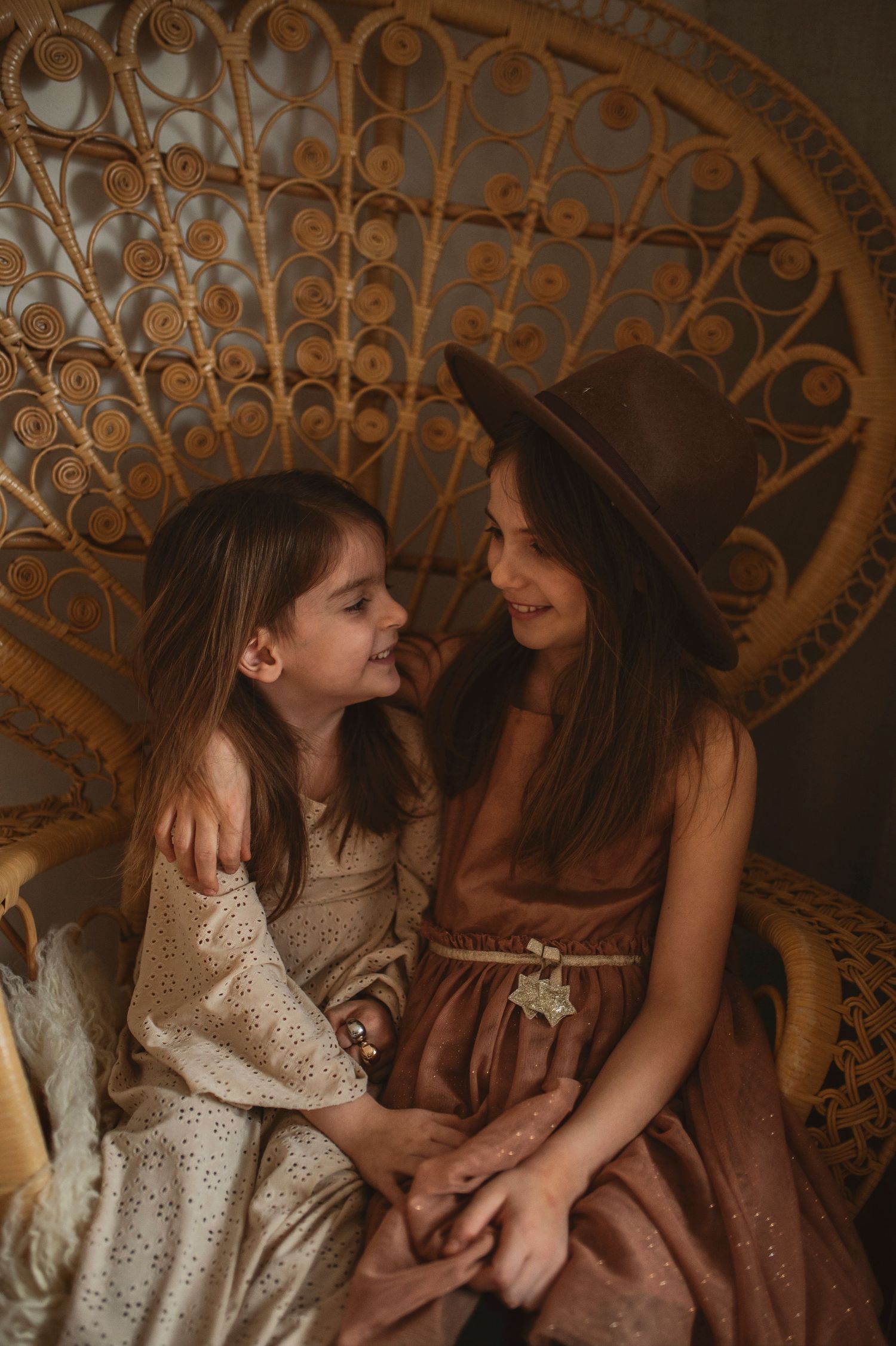 An intimate portrait against a peacock chair backdrop showing genuine connection and joy.