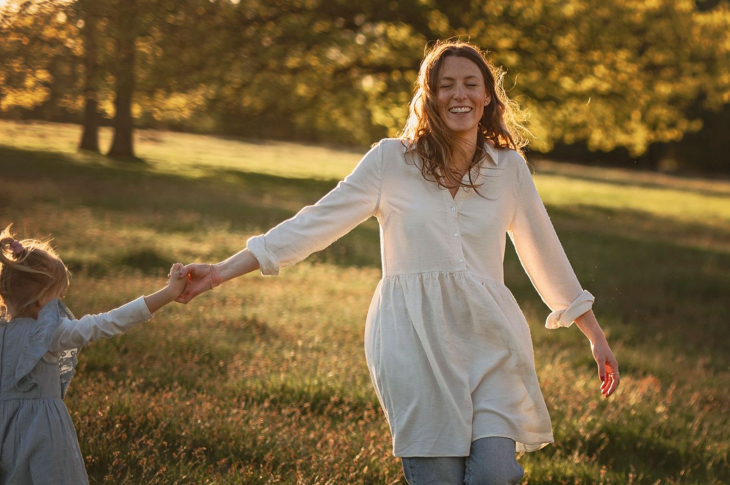 Familjefotografering i Skåne med mamma och barn i solig park i mjukt naturligt ljus.