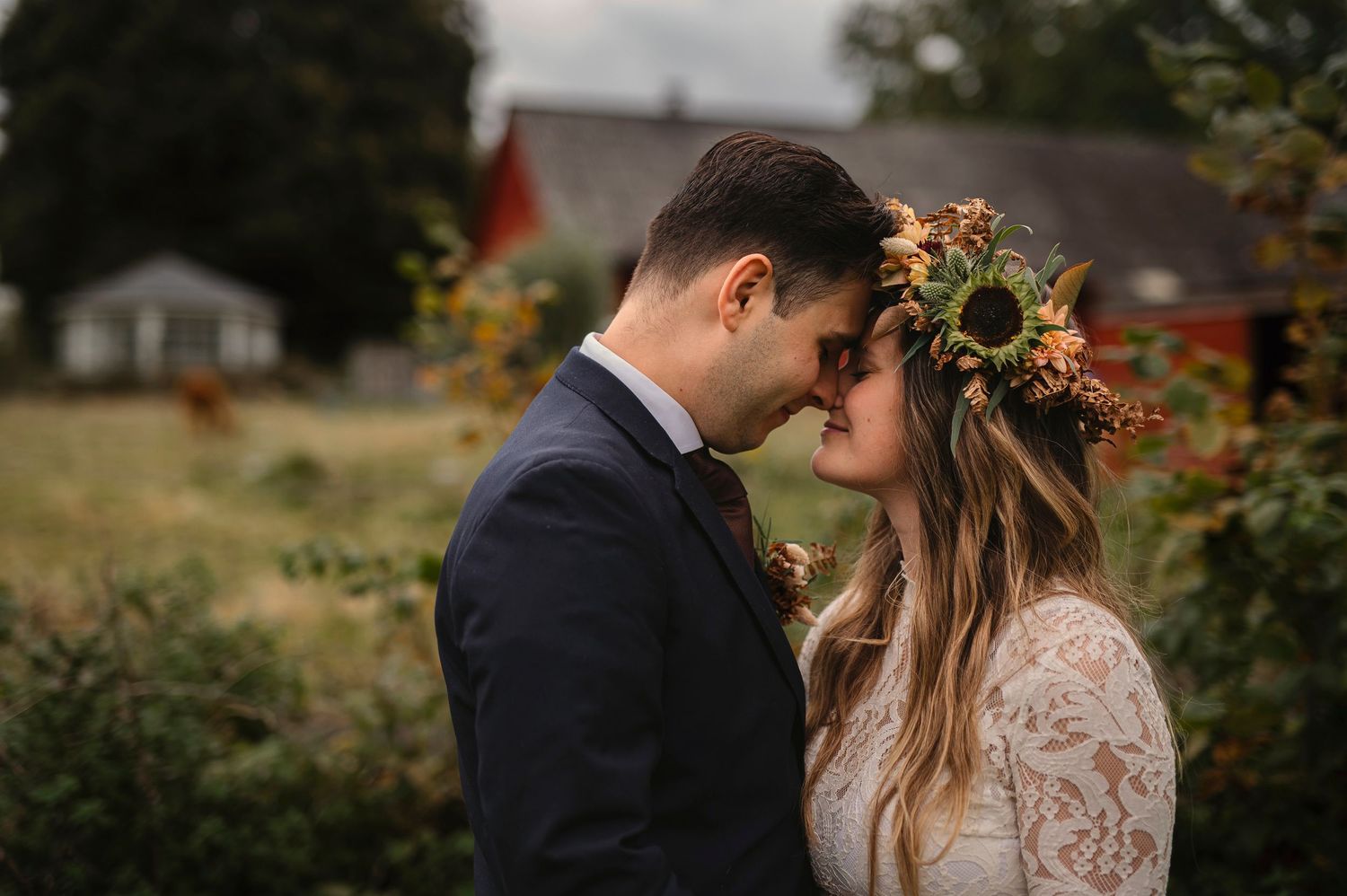 Wedding photography in Skåne at Hillarps Loge with bride wearing a sunflower floral crown and groom in navy suit sharing a romantic moment