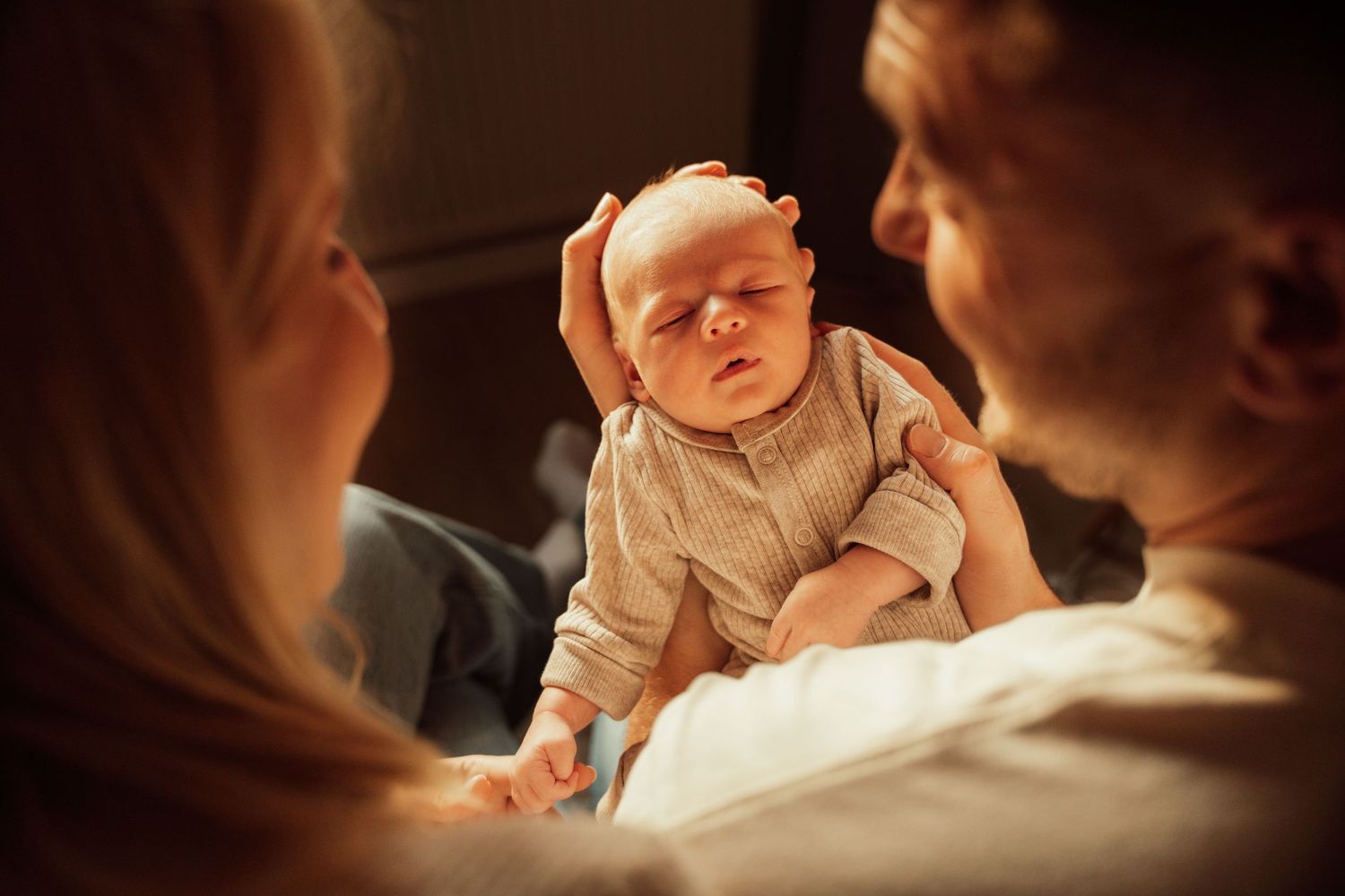 Baby die bewonderd wordt door zijn ouders tijdens een newbornshoot in Ameide